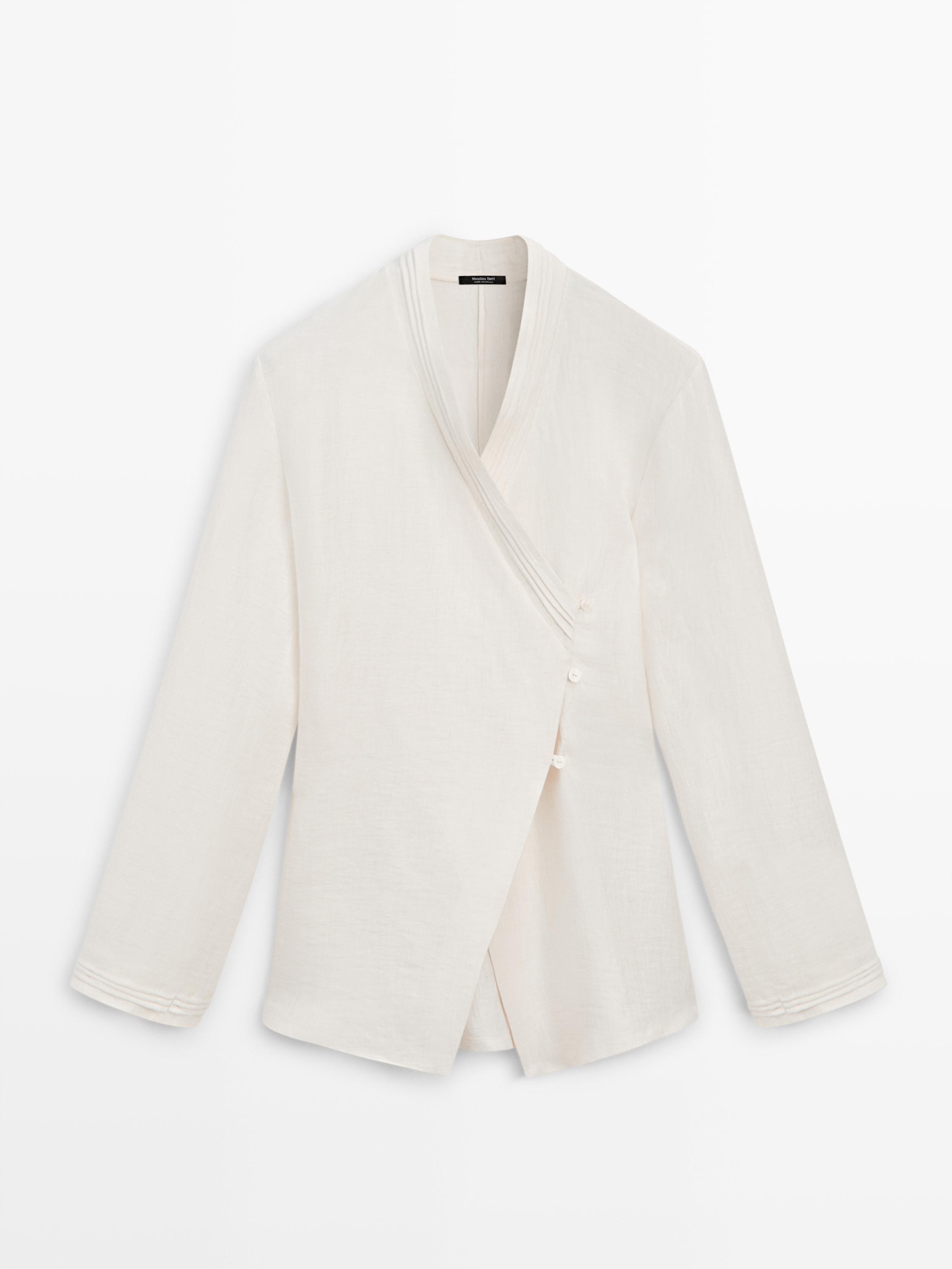 Front view of an kimono with a crossover closure and side buttons. Long sleeves with seam detailing on the cuffs.