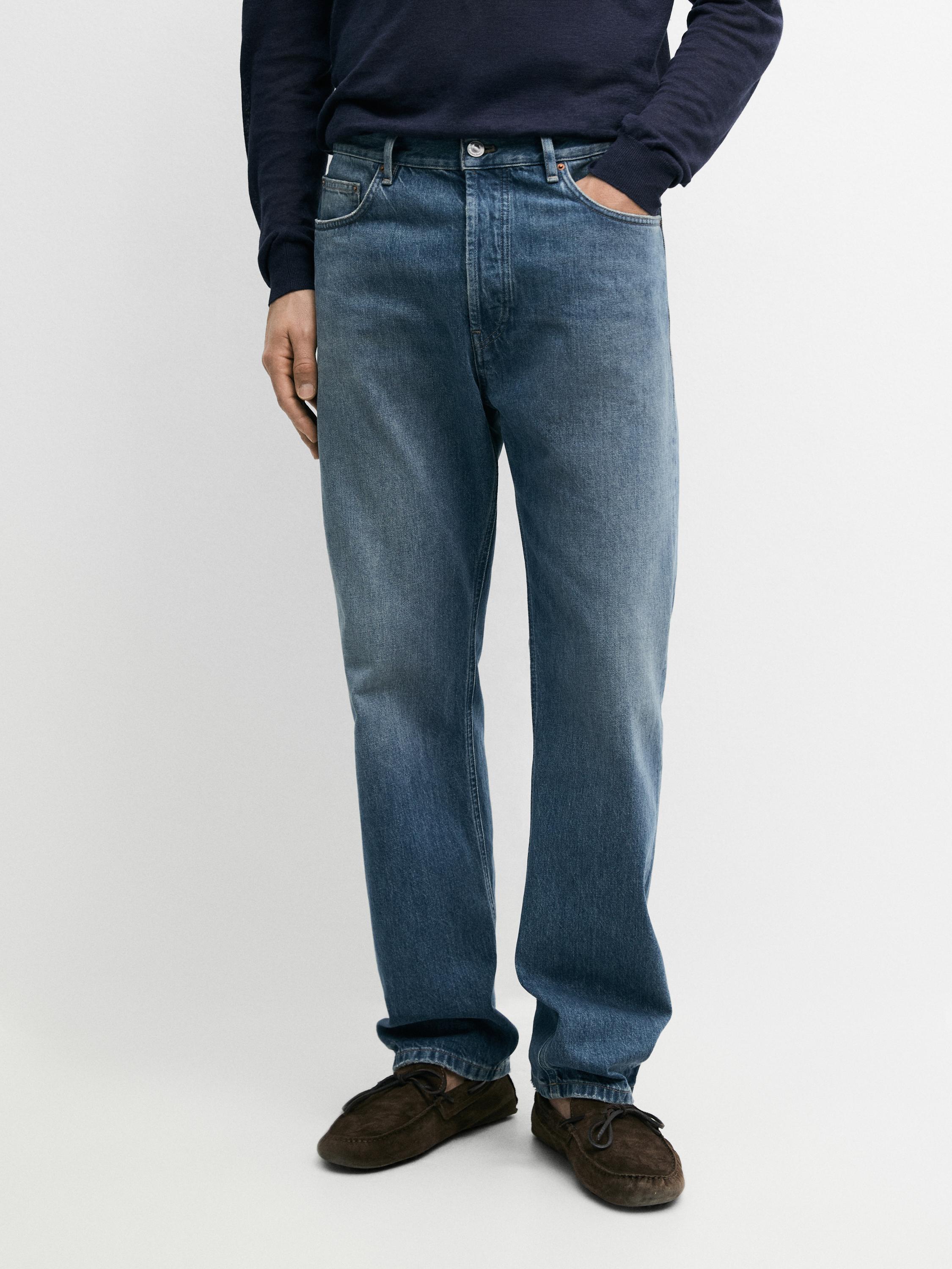 Conjunto de jeans índigo de corte reto com bolsos frontais e traseiros visíveis.