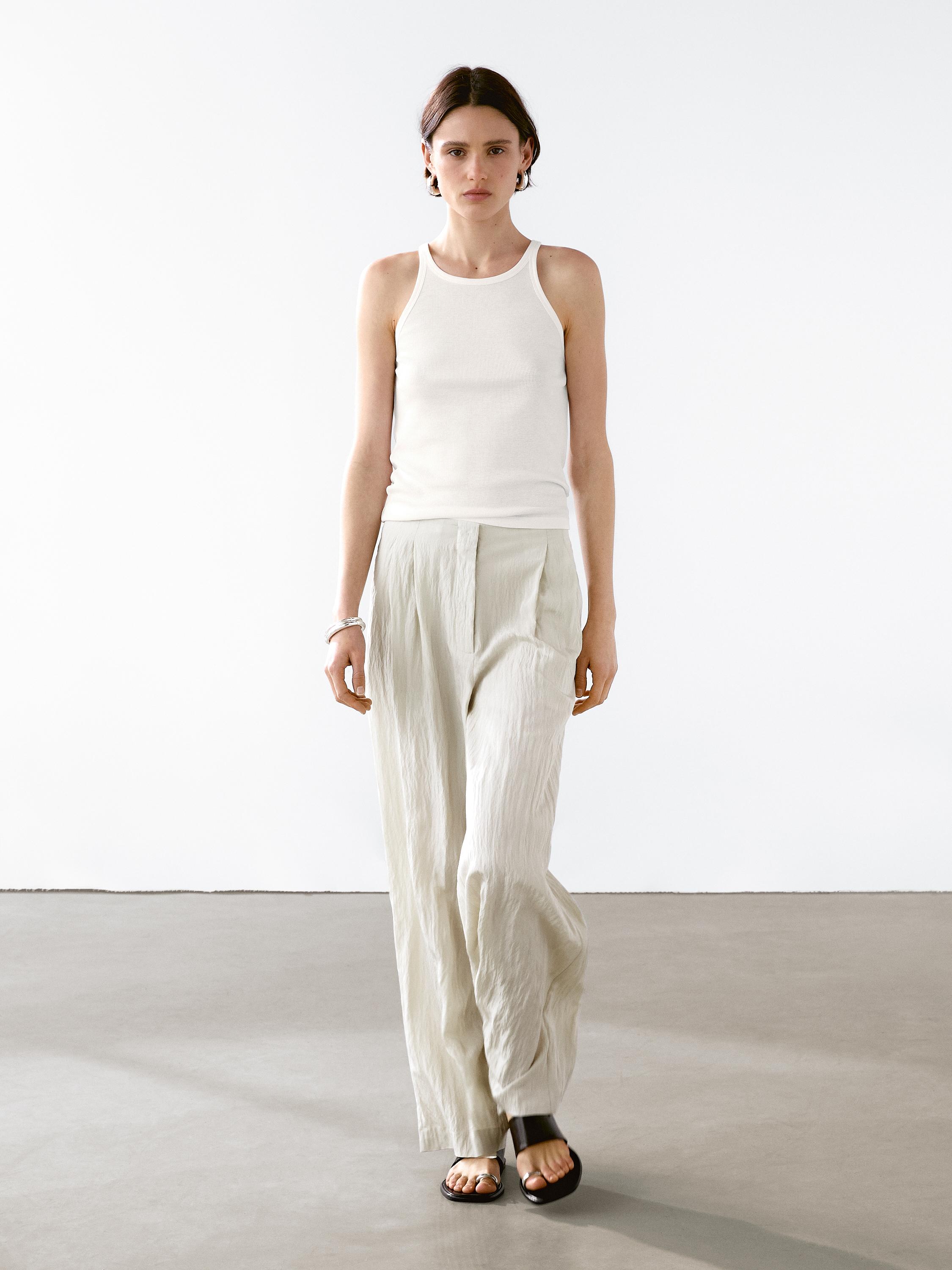 Ensemble pantalon technique à pinces et débardeur blanc.