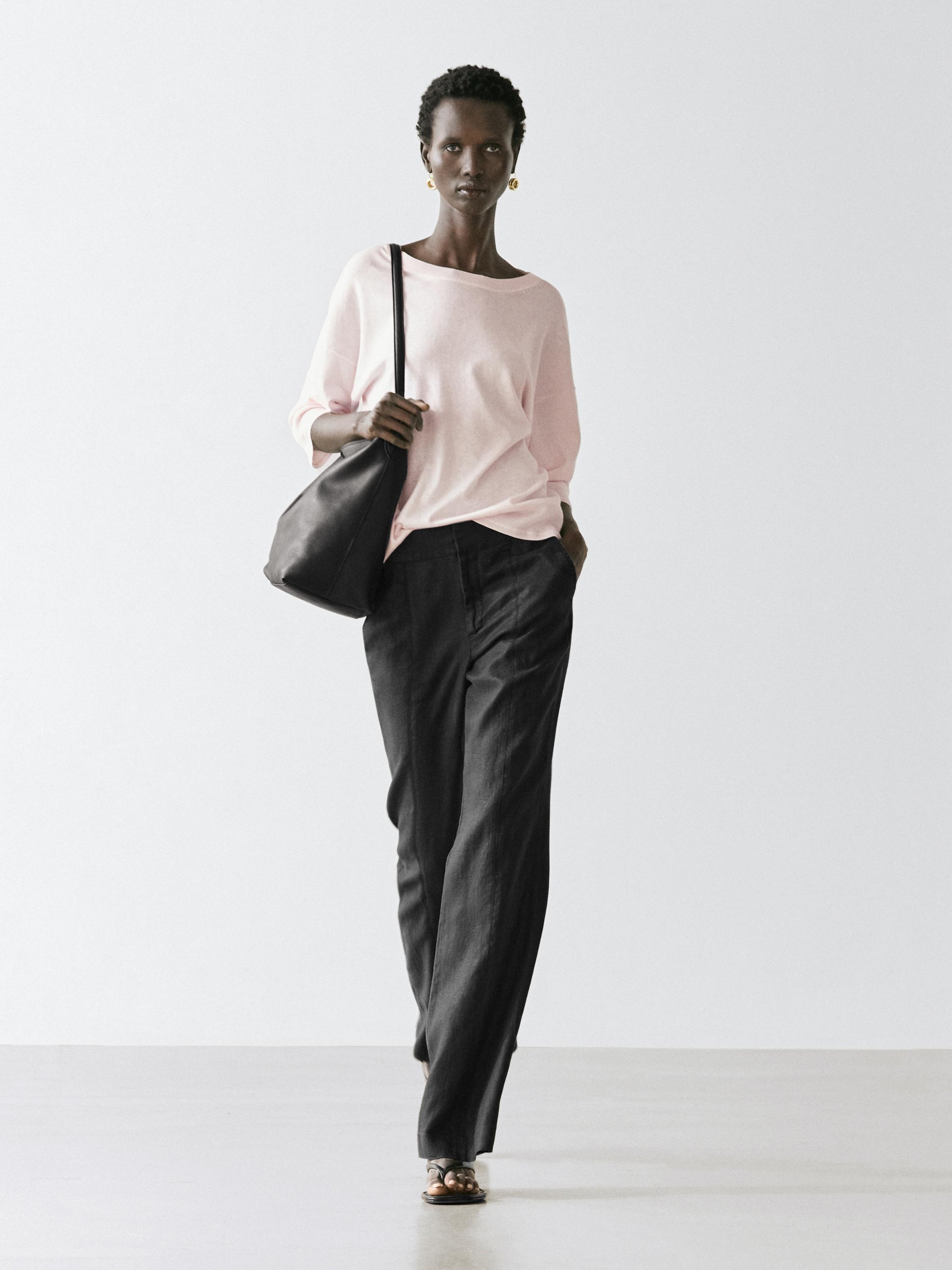 Langärmeliges altrosafarbenes Jersey-Set und weite schwarze Hosen.