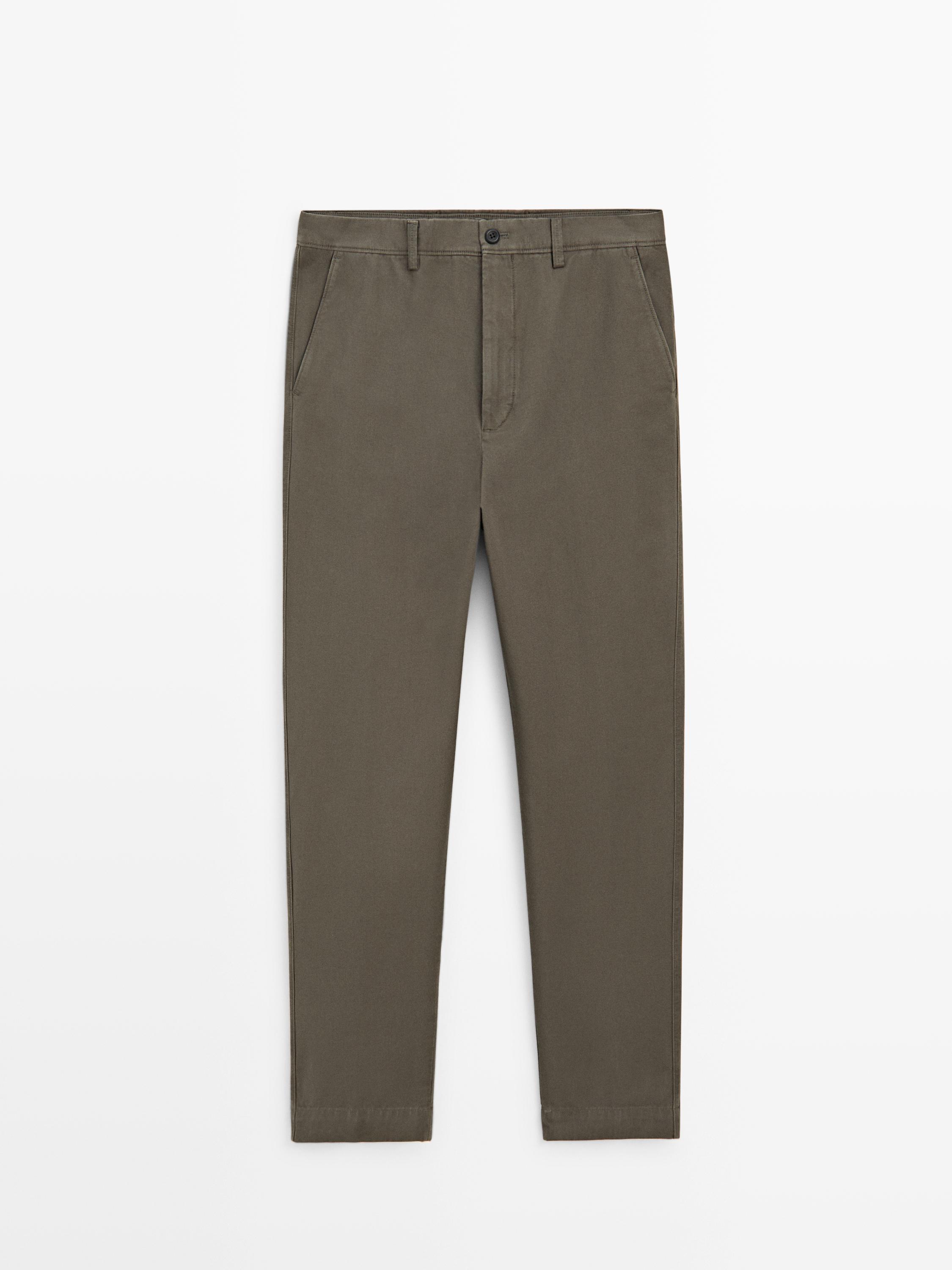 Vista frontal de pantalón verde tapered fit con bolsillos laterales y cierre de botón.