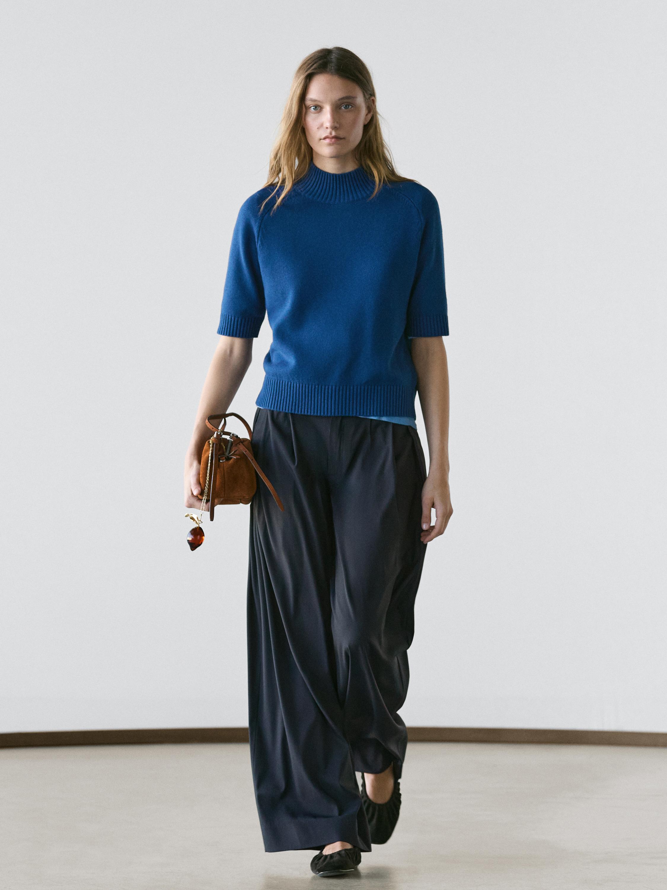 Dunkelblaues Kurzarm-Jersey-Set und schwarze weite Hosen.