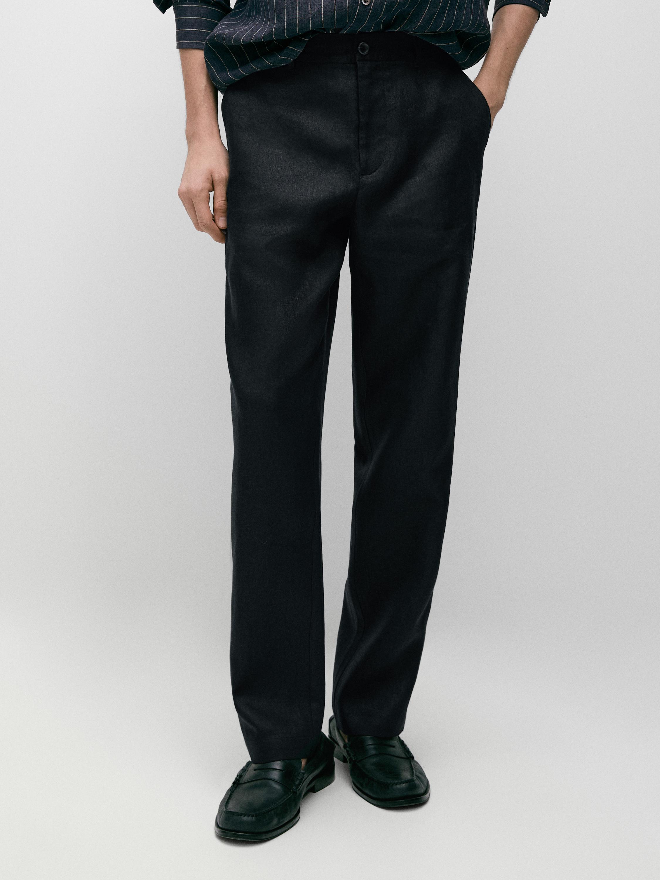 Conjunto de pantalón azul marino tapered fit con bolsillos laterales y cierre de botón, combinado con zapatos negros.