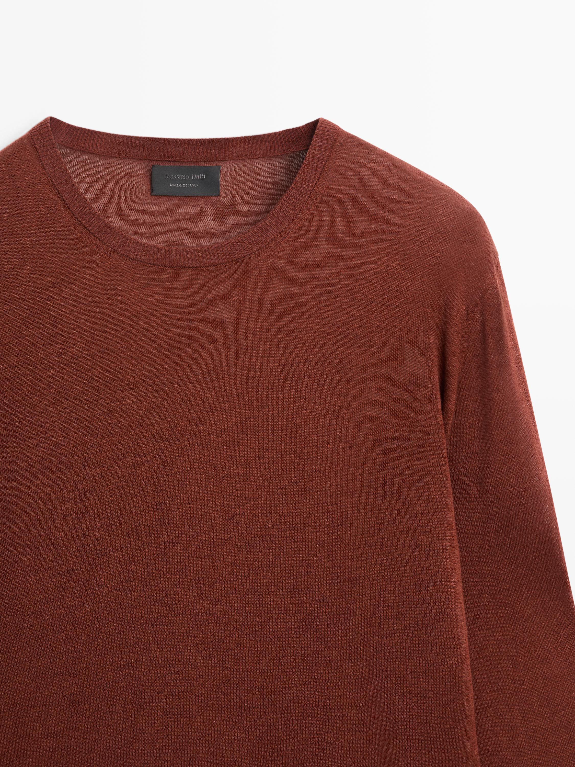 "Plano medio de jersey marrón con cuello redondo y etiqueta visible en el interior del cuello."