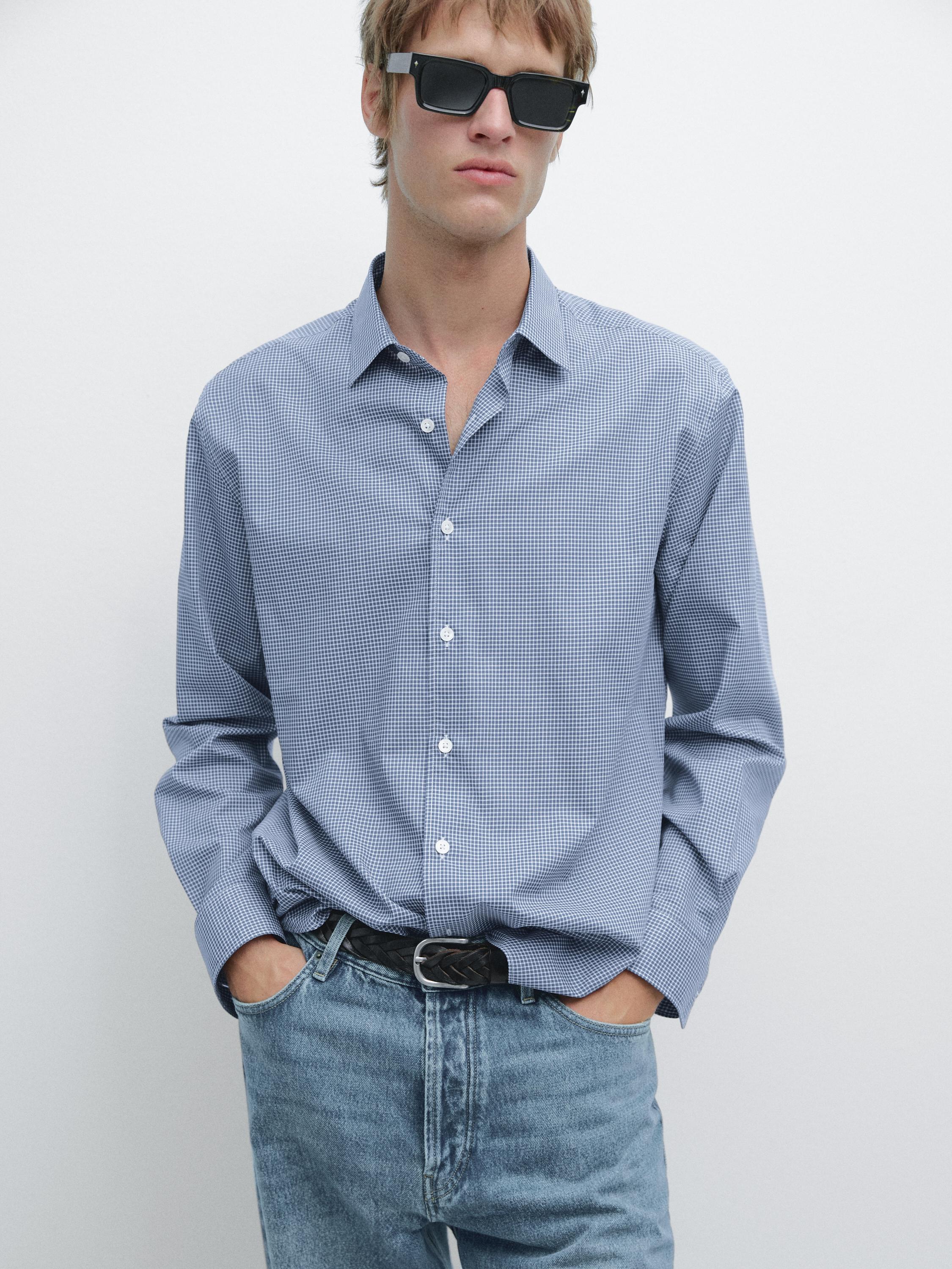 Ensemble comprenant une chemise bleu canard à manches longues avec des boutons blancs et un jean bleu.