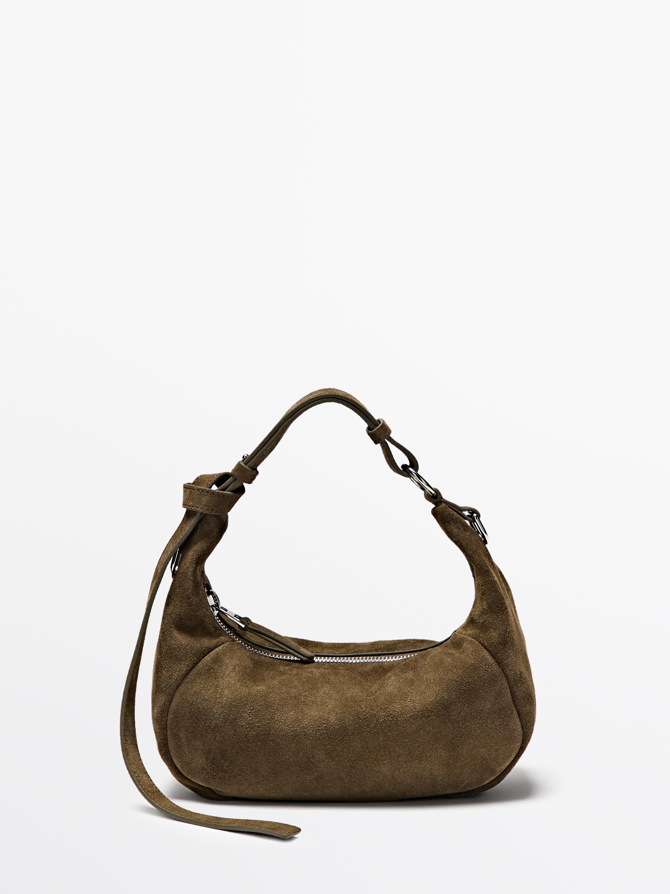 Zijaanzicht van kaki tas met verstelbare schouderband en ritssluiting.