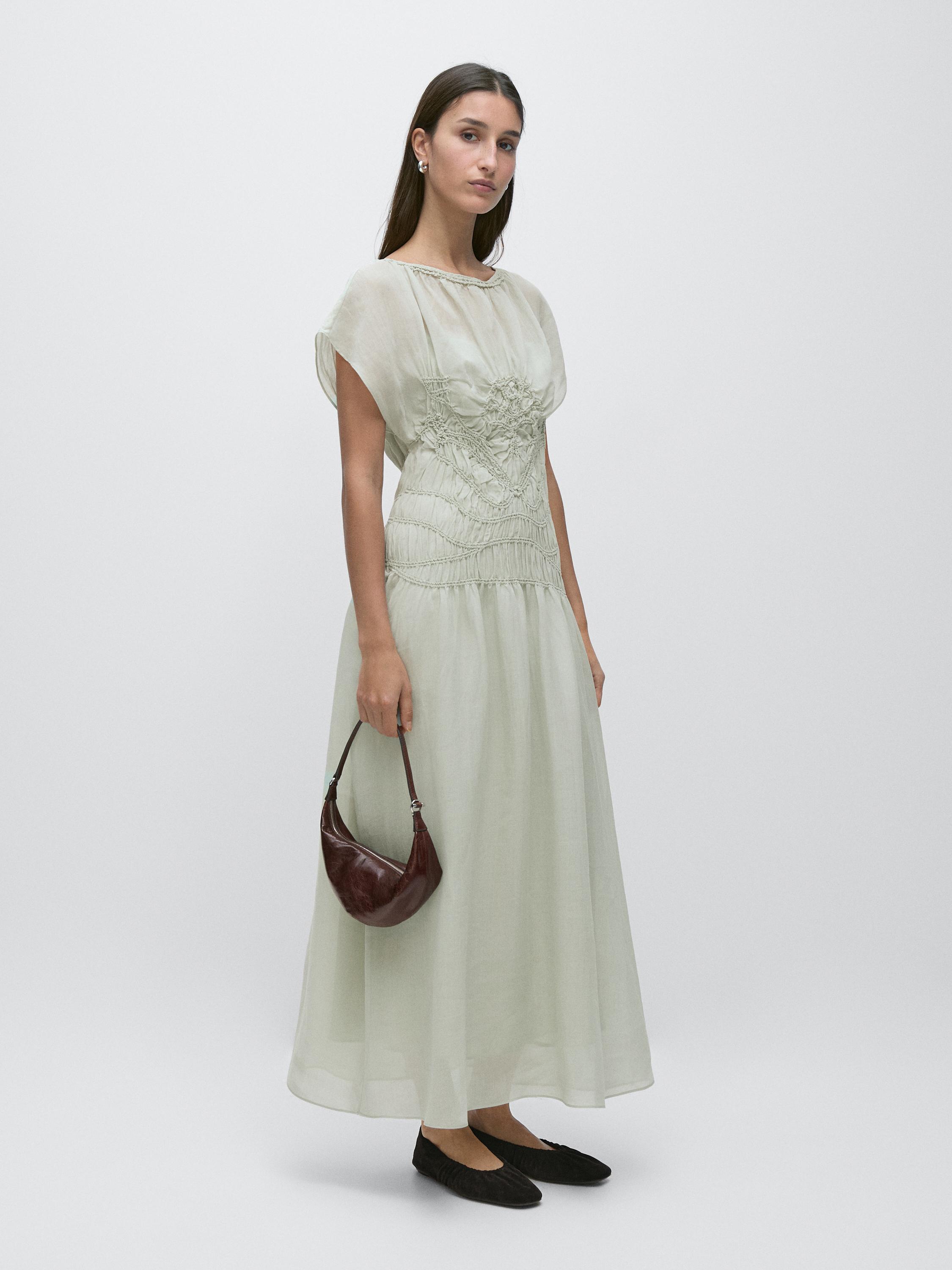 Flowy mint-colored long dress set with embroidered detail on the chest, brown bag, and black shoes.