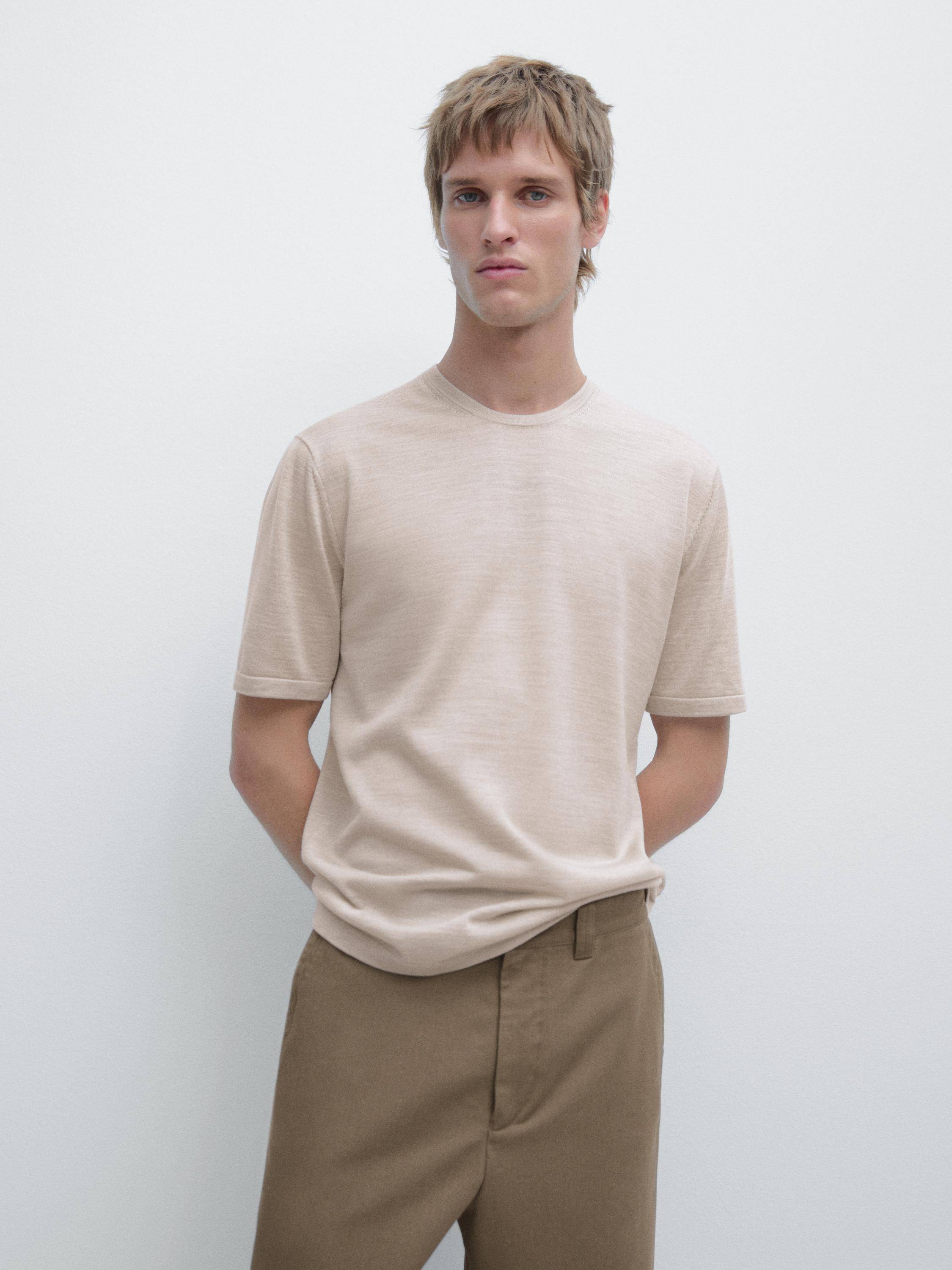Completo di t-shirt beige a maniche corte e pantaloni marrone chiaro.