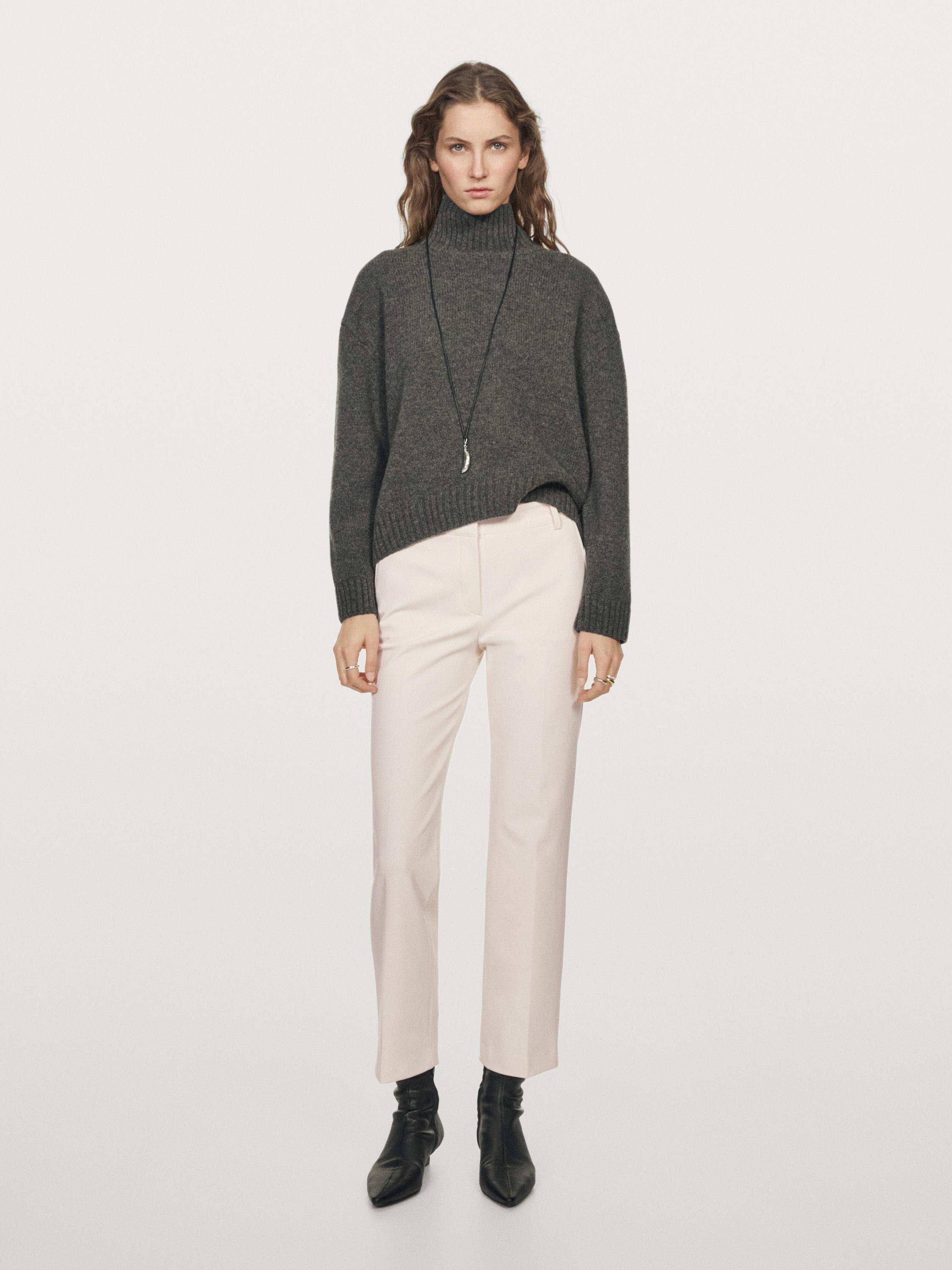 Gray turtleneck sweater and black straight tech pants set, with black boots.