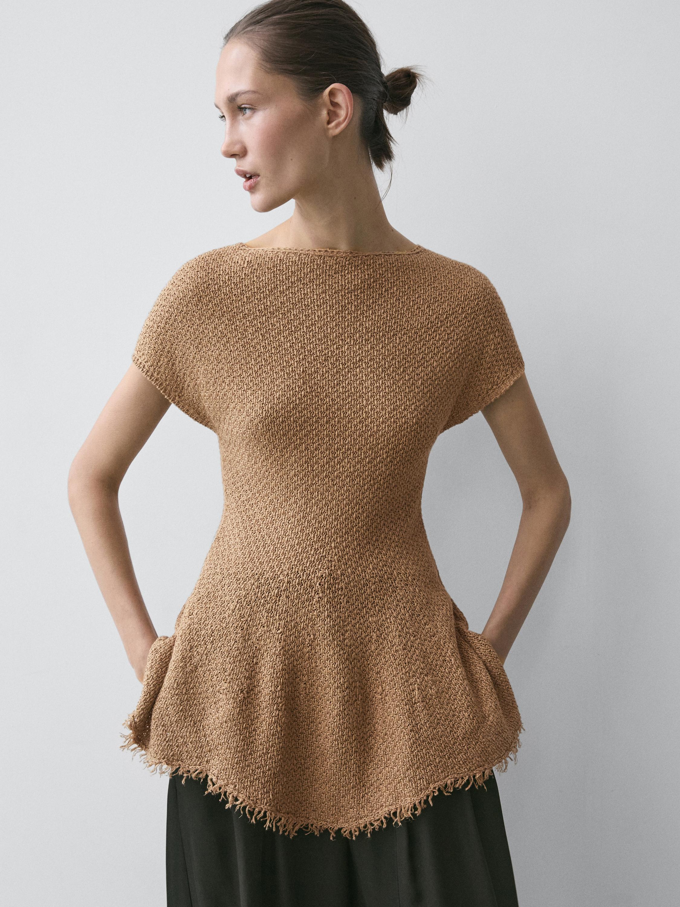 Frayed toasted top set with short sleeves and side pockets, over a black skirt.