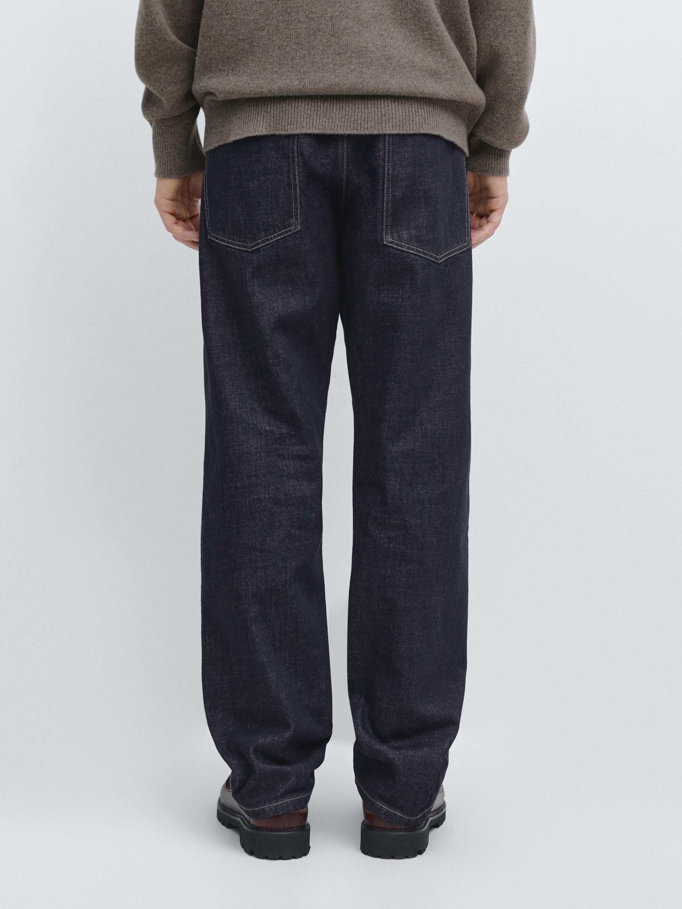 Conxunto de [[jeans]] azul de corte relaxado con petos traseiros visibles.