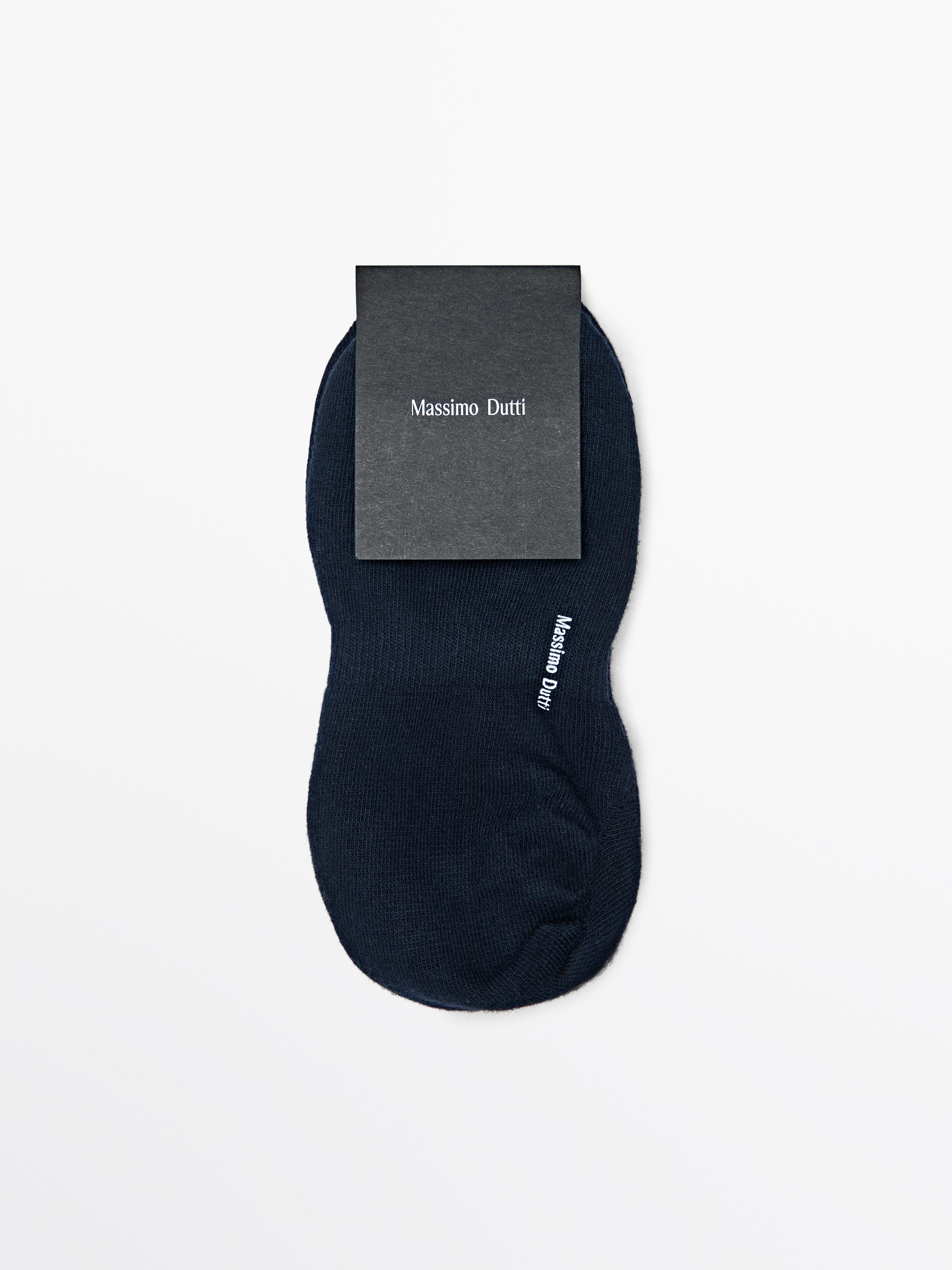 Vue frontale d'une chaussette bleu marine avec le texte "Massimo Dutti" visible sur le côté.