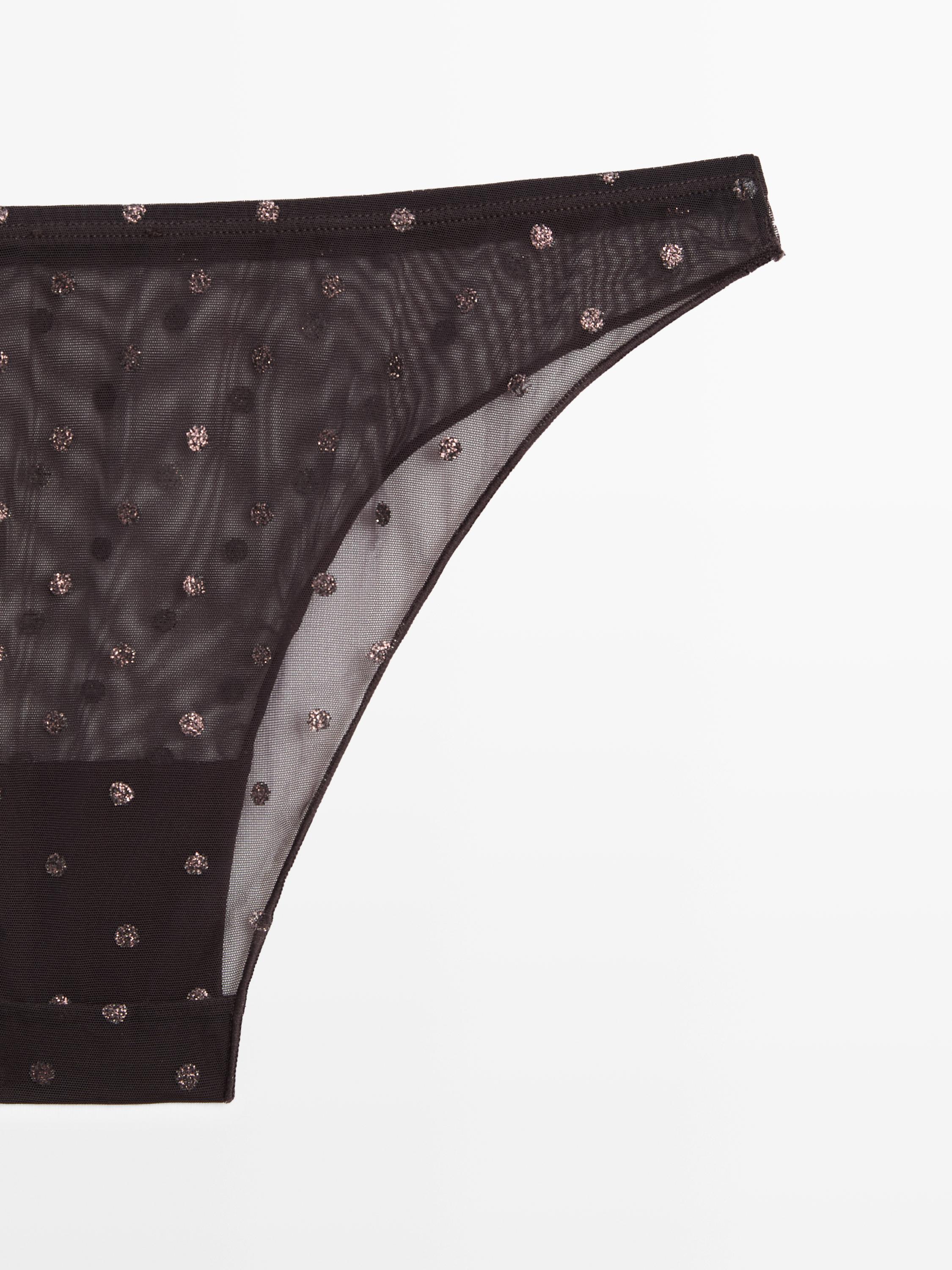 Detalle de braga marrón toupa con estampado de puntos brillantes.