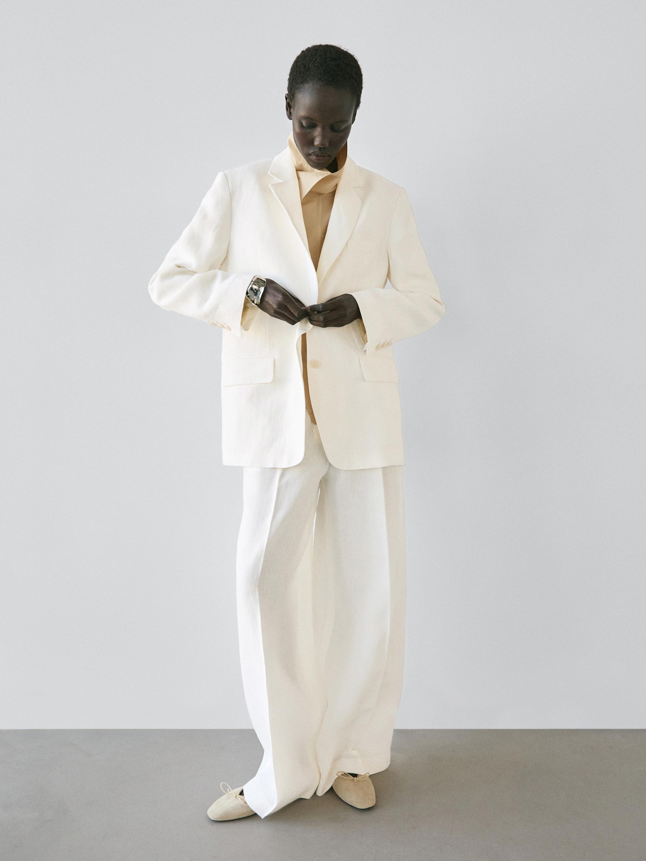 Krem rengi ceket ve pantolon takımı, ön cepli ceket ve geniş paça pantolon.