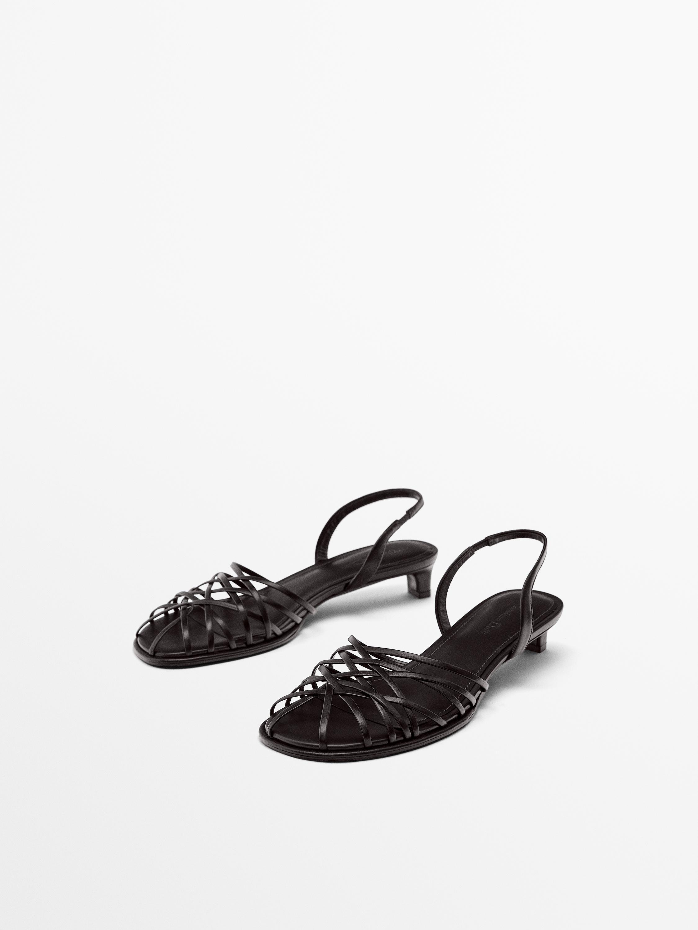 منظر أمامي لصنادل سوداء بسيور متشابكة وكعب منخفض.