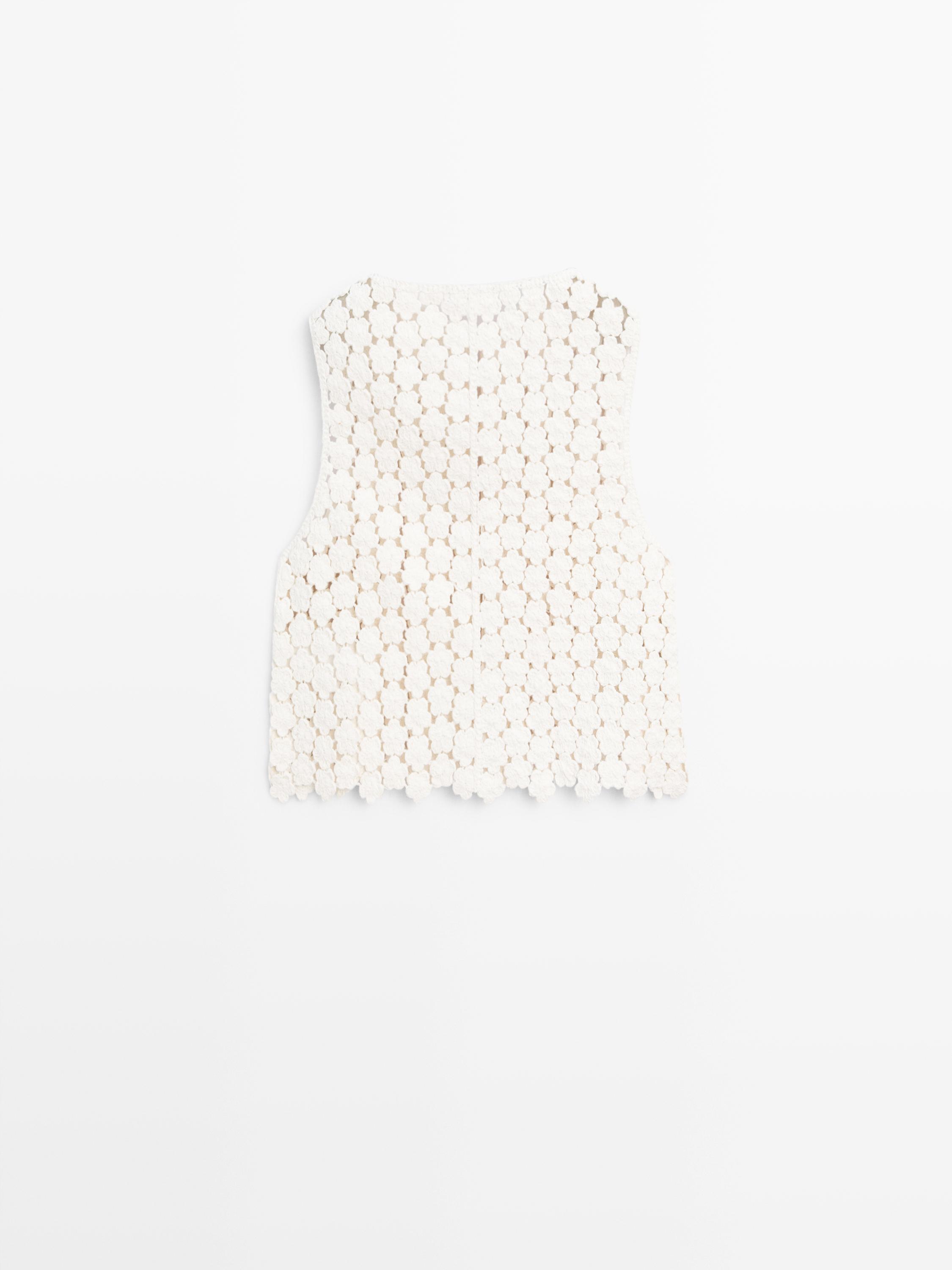 Πίσω όψη ακατέργαστου γιλέκου κροσέ με λεπτομέρεια λουλουδιών.