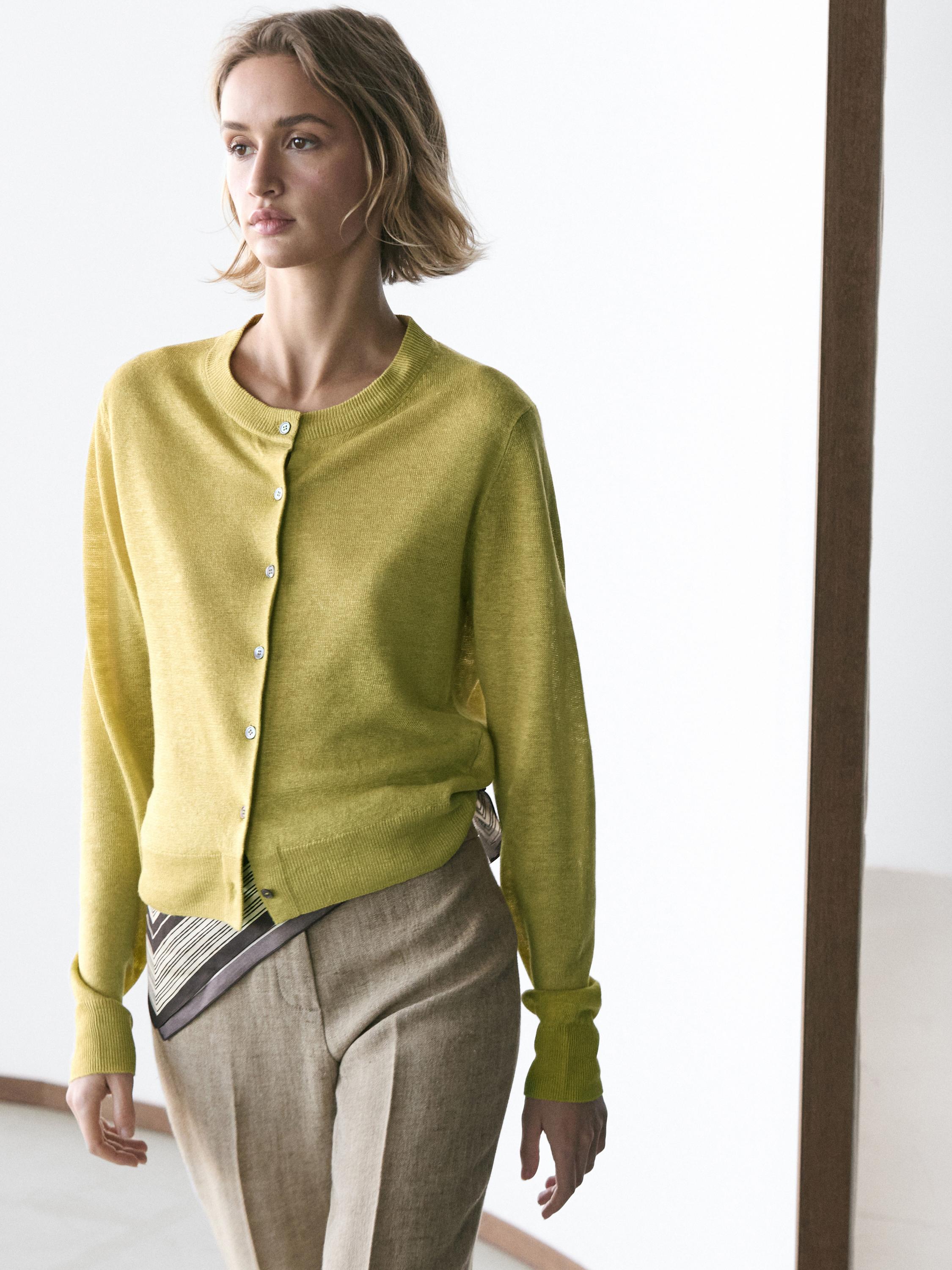 Conjunto de cárdigan lima con botones y pantalones beige.