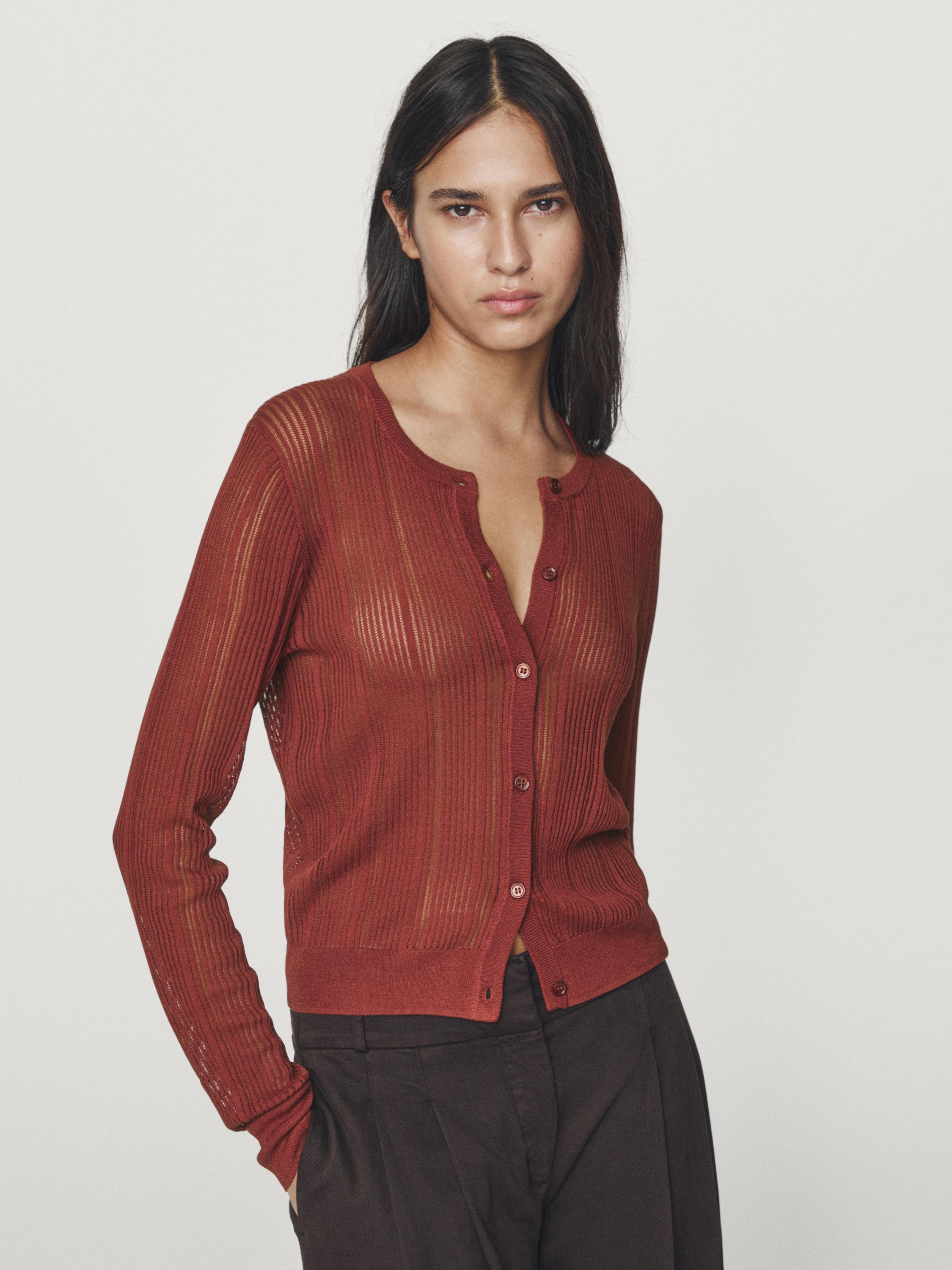 전면 버튼과 긴 소매가 있는 빨간색 오픈워크 가디건의 미디엄 샷.