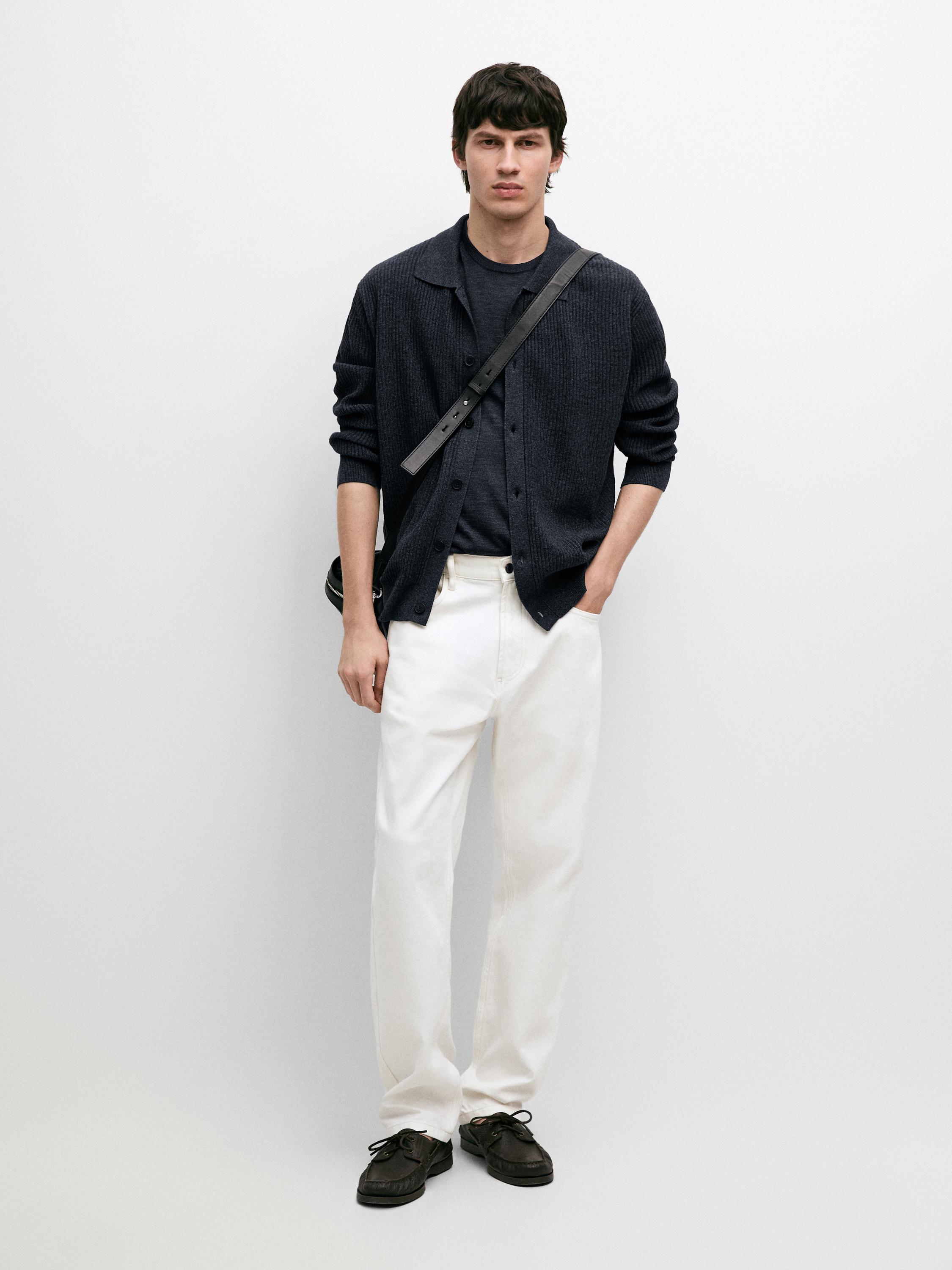 Conxunto de cárdigan azul índigo con botóns, camiseta azul, pantalóns brancos e zapatos negros.