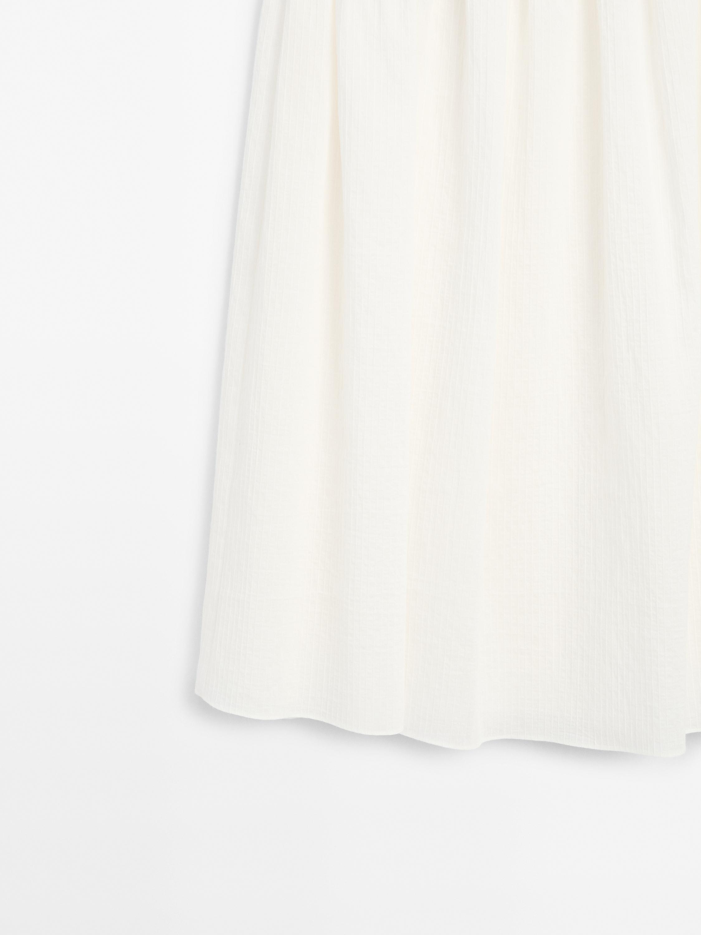 Long pleated skirt with fabric detail