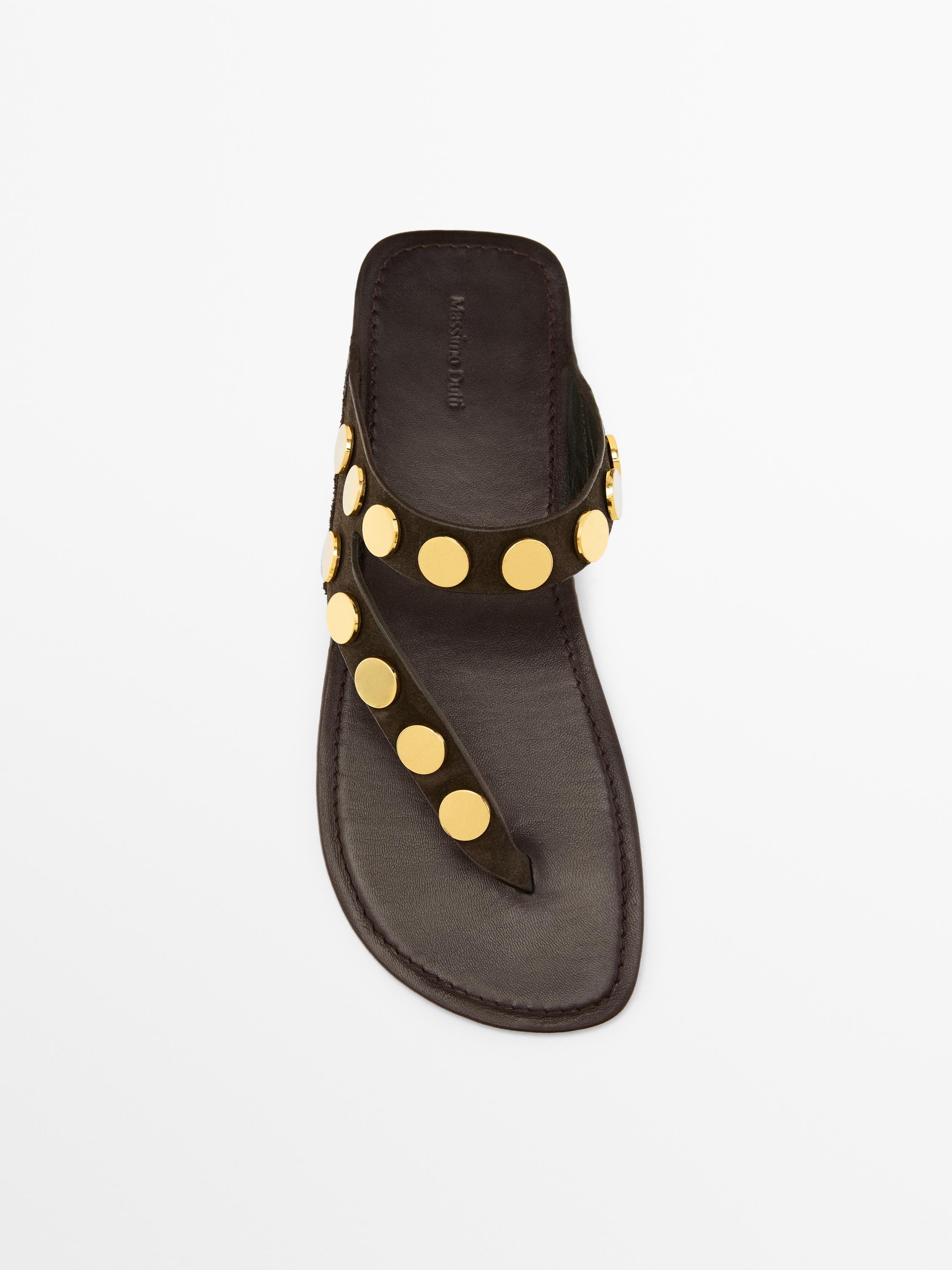 Bovenaanzicht van bruine sandaal met gouden studs op de band en centrale riem.