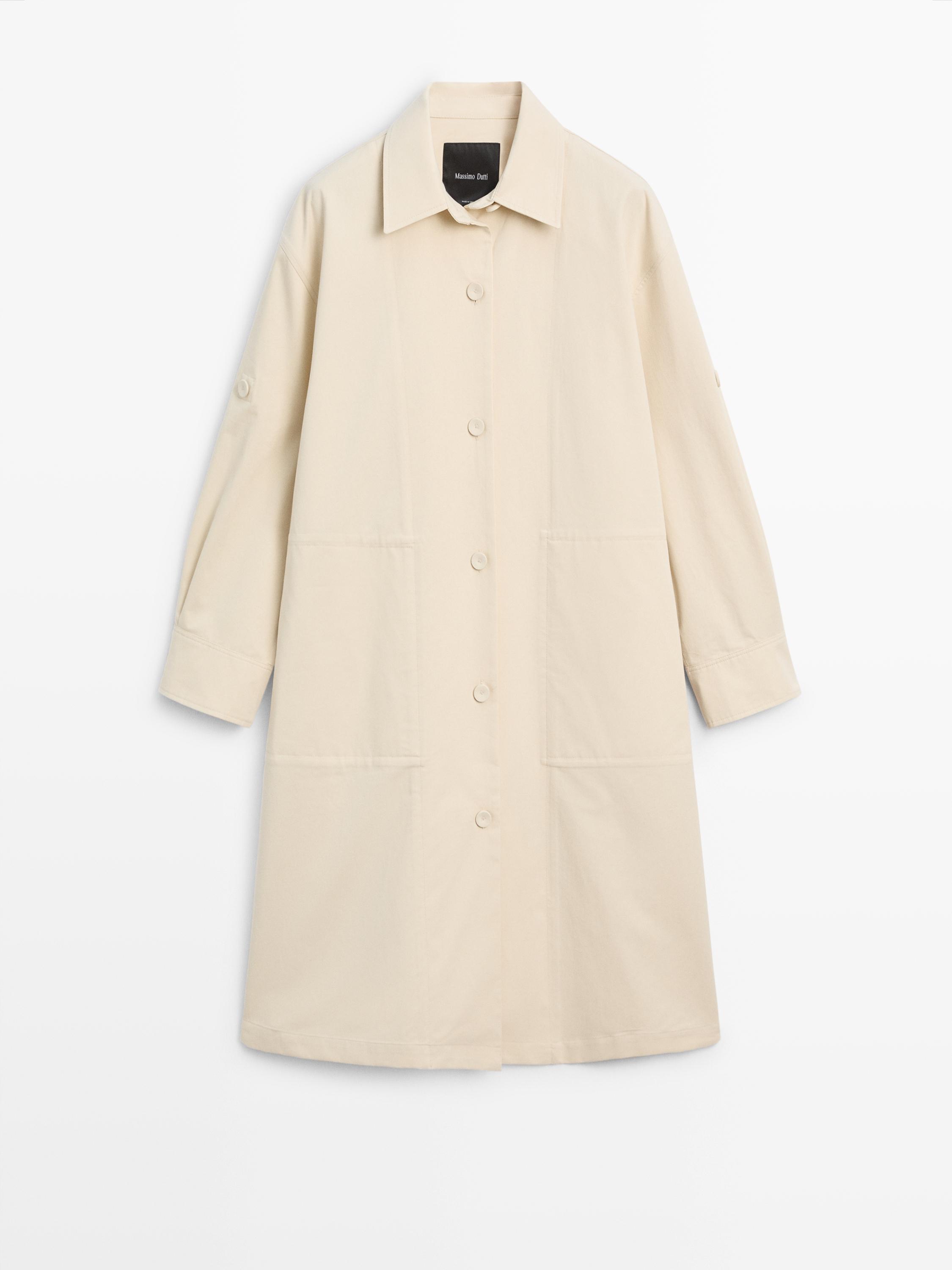 Front view of a light yellow trench coat with roll-up sleeves, central button placket, and side pockets.