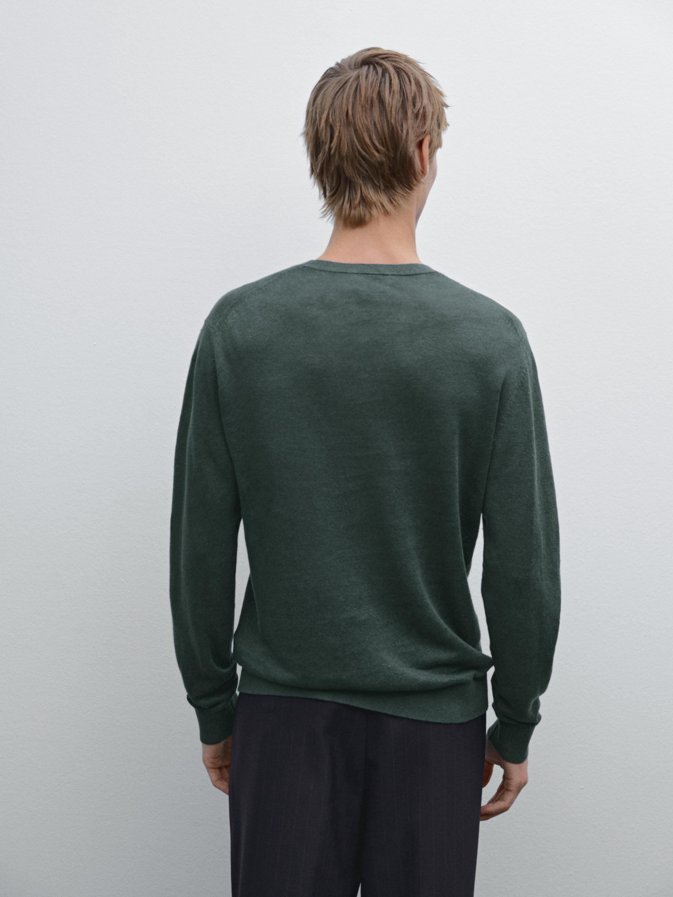 Vue arrière d'un pull vert foncé à manches longues.