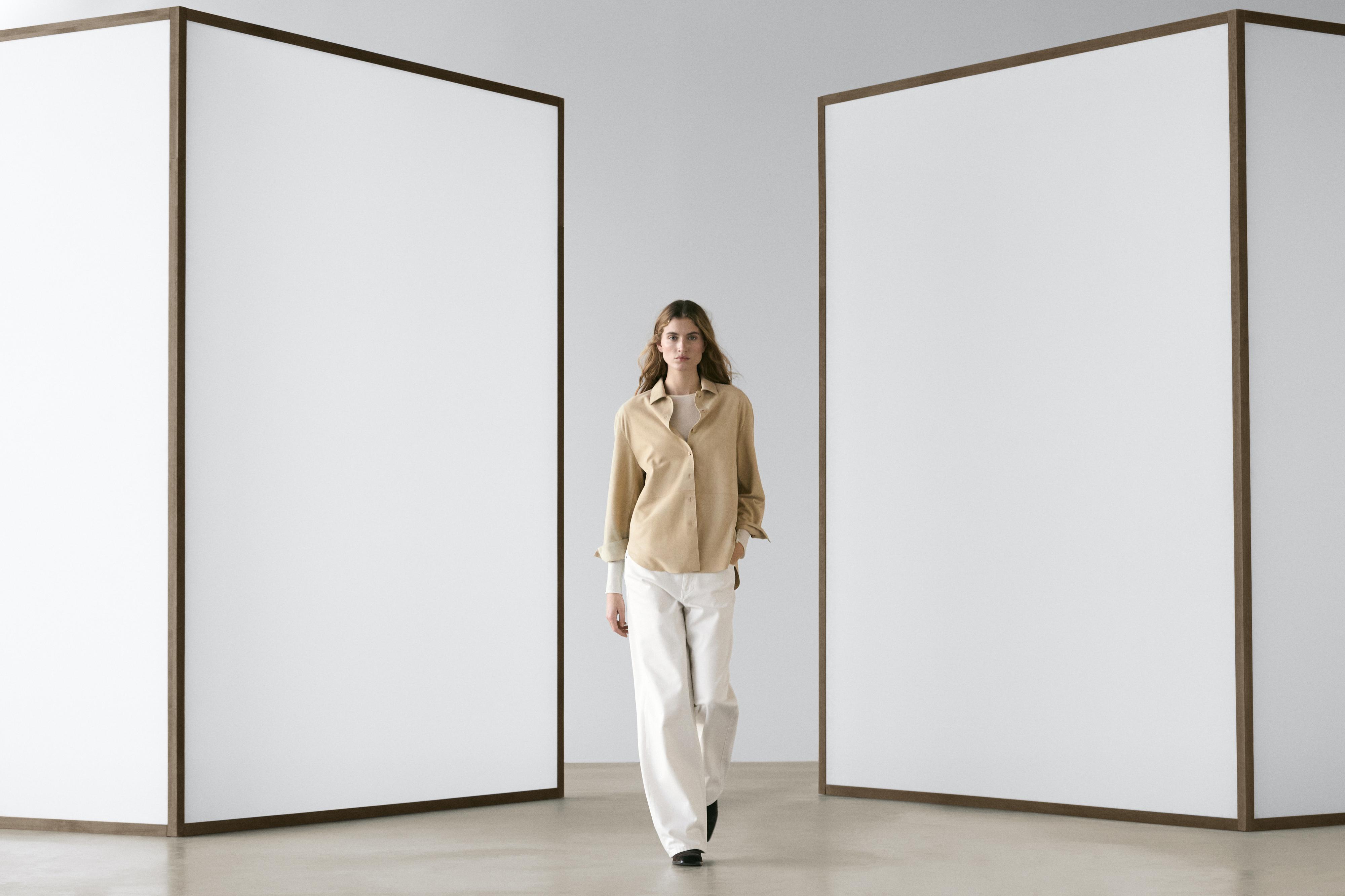 Pikkade varrukatega liivavärvi särgi ja laiade valgete pükste komplekt.