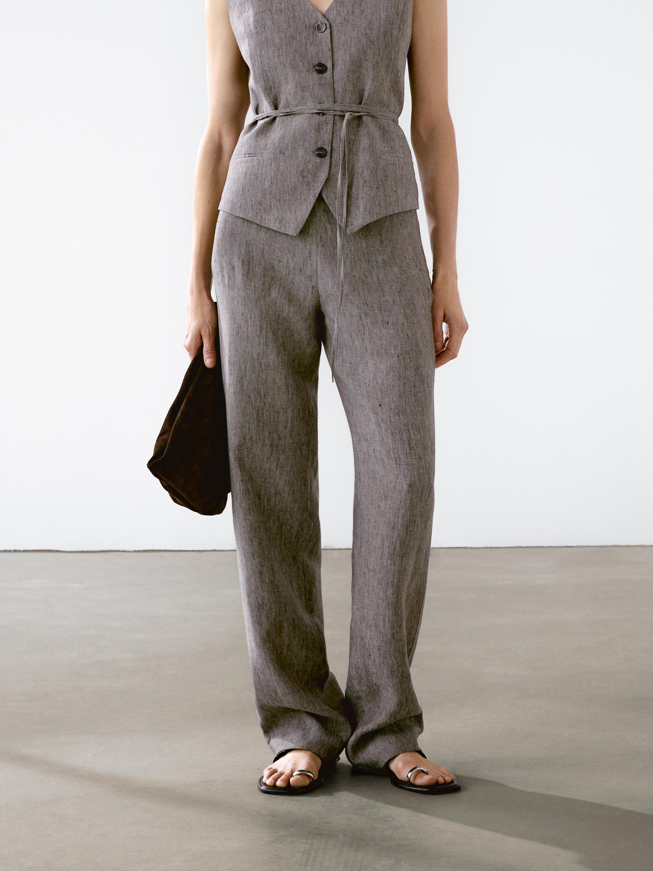 طقم صدرية وبنطلون رمادي بأزرار وحزام، صندل أسود.