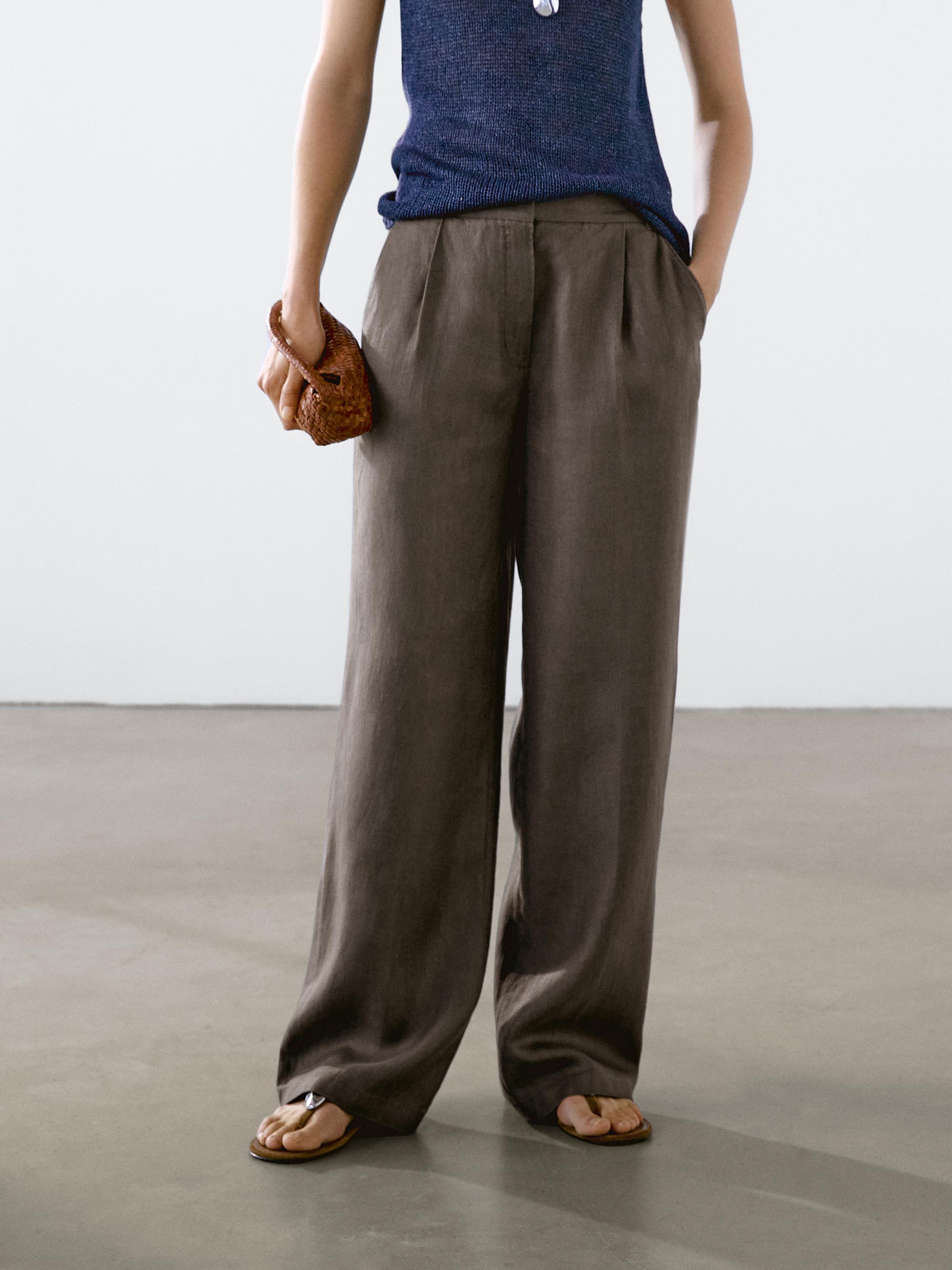 Conjunto de pantalones anchos marrones y top azul oscuro sin mangas, con bolsillos laterales visibles.