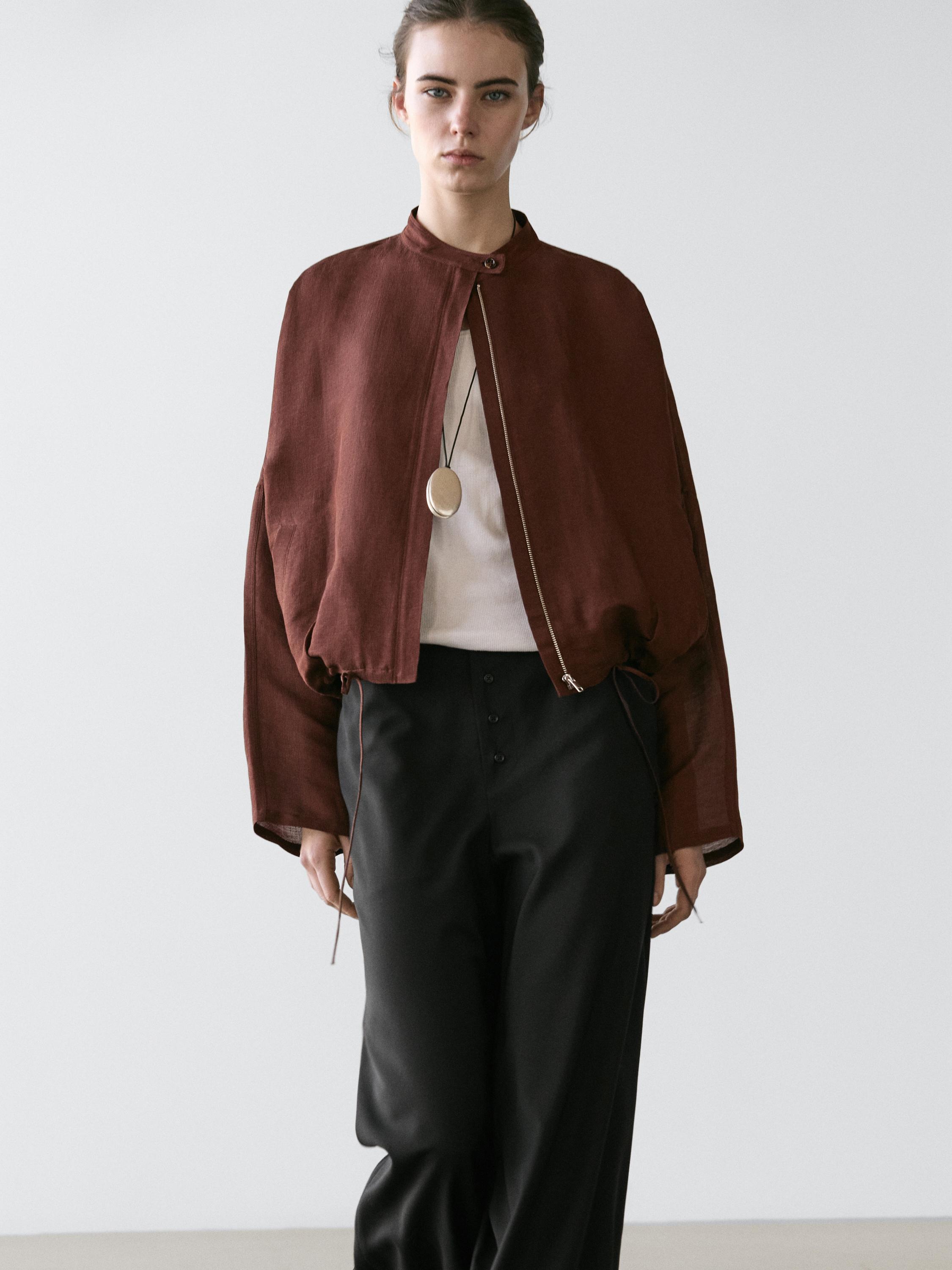 ชุดเสื้อแจ็คเก็ตบอมเบอร์สีน้ำตาลแบบมีกระดุมและกางเกงขายาวสีดำแบบมีกระดุมด้านหน้า