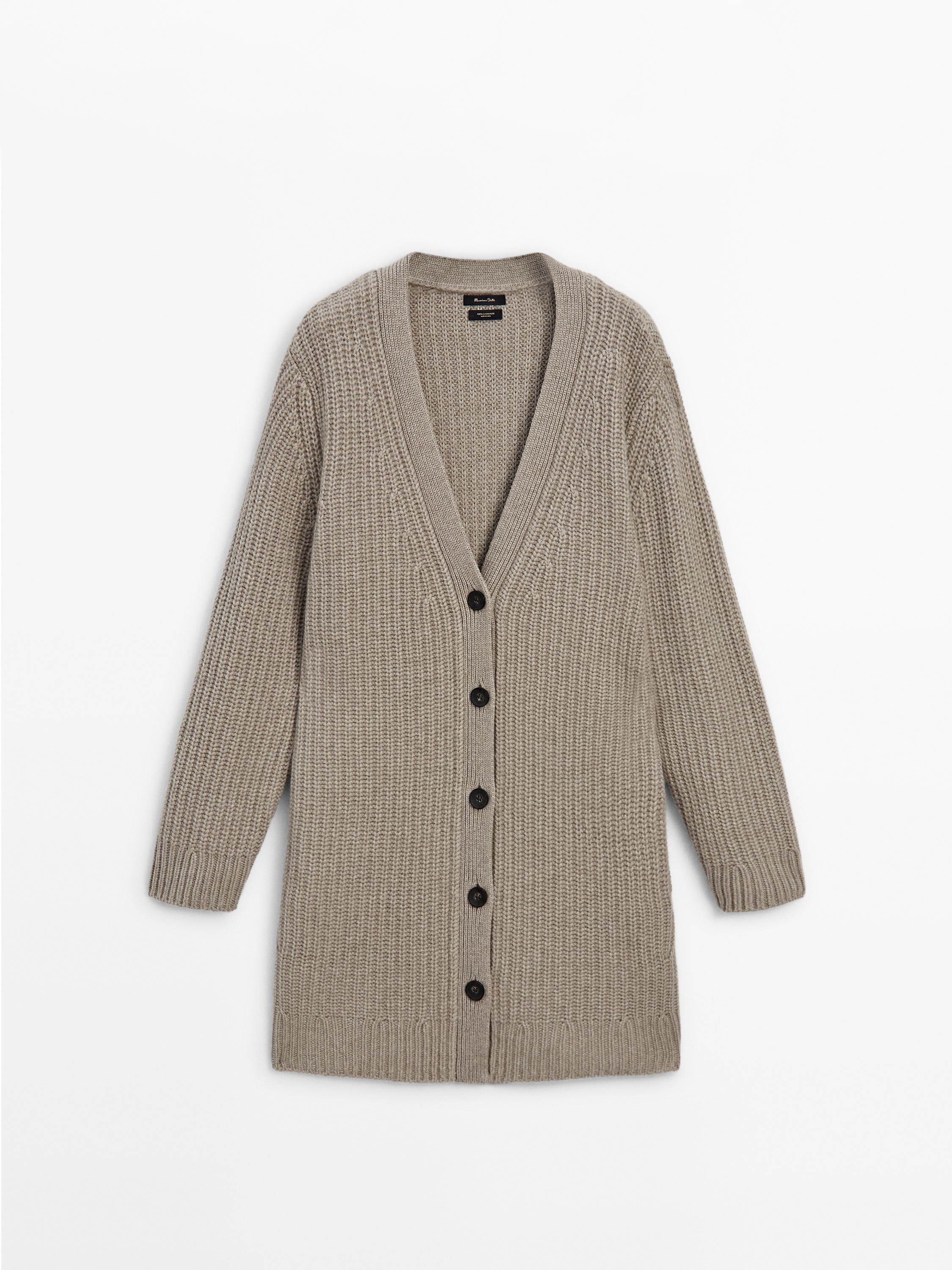 Vista frontal de cárdigan beige con botones negros y mangas largas.