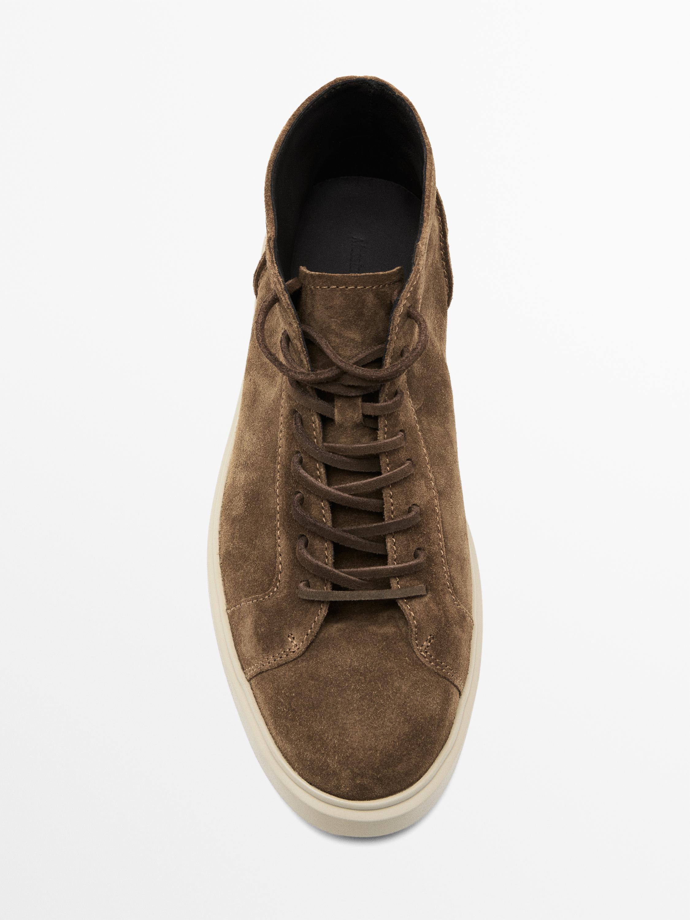 Top view of brown athletic shoe with laces and white sole.