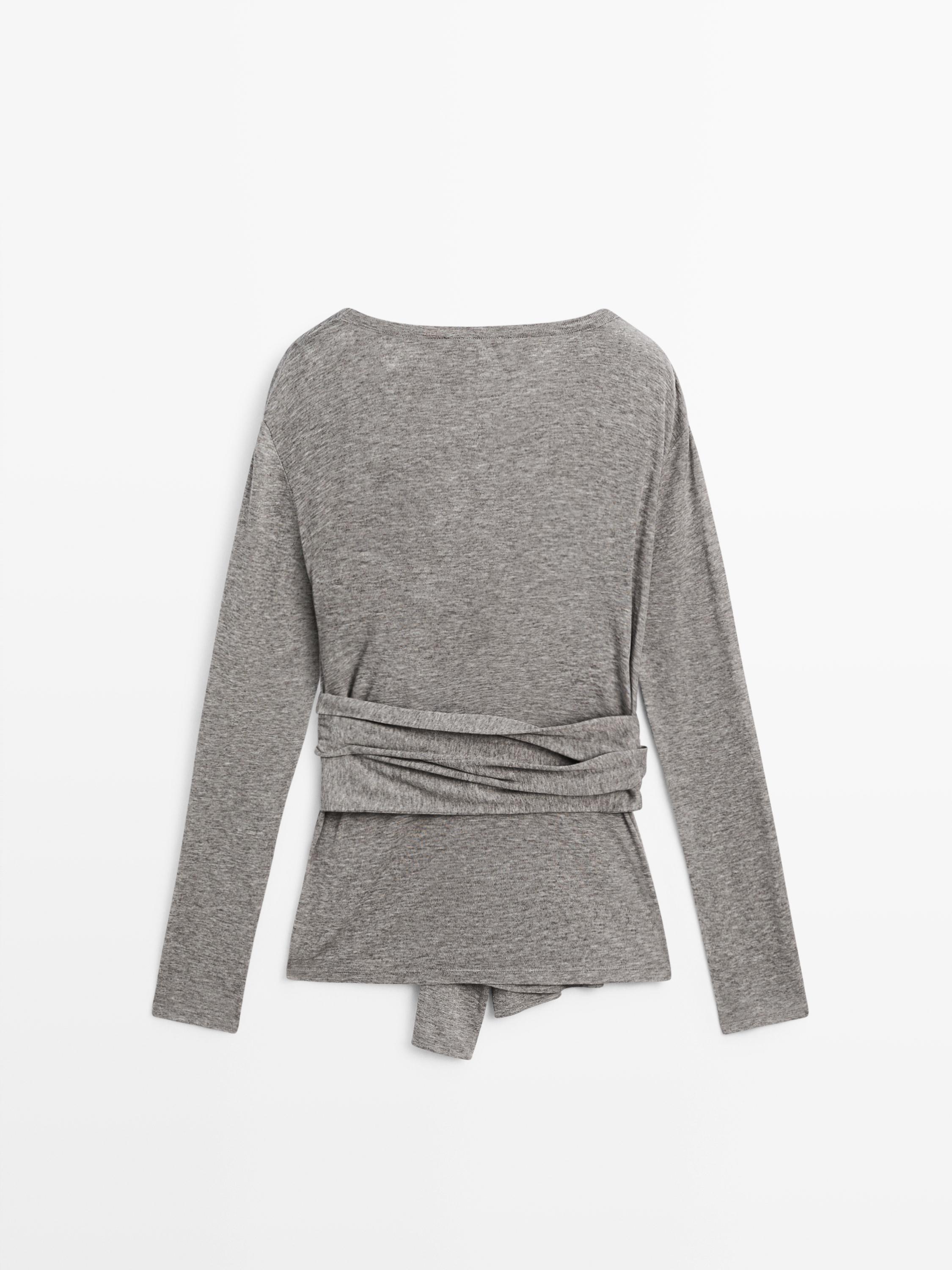 Pamje e pasme e bluzës gri me mëngë të gjata me detaj lidhës në bel.