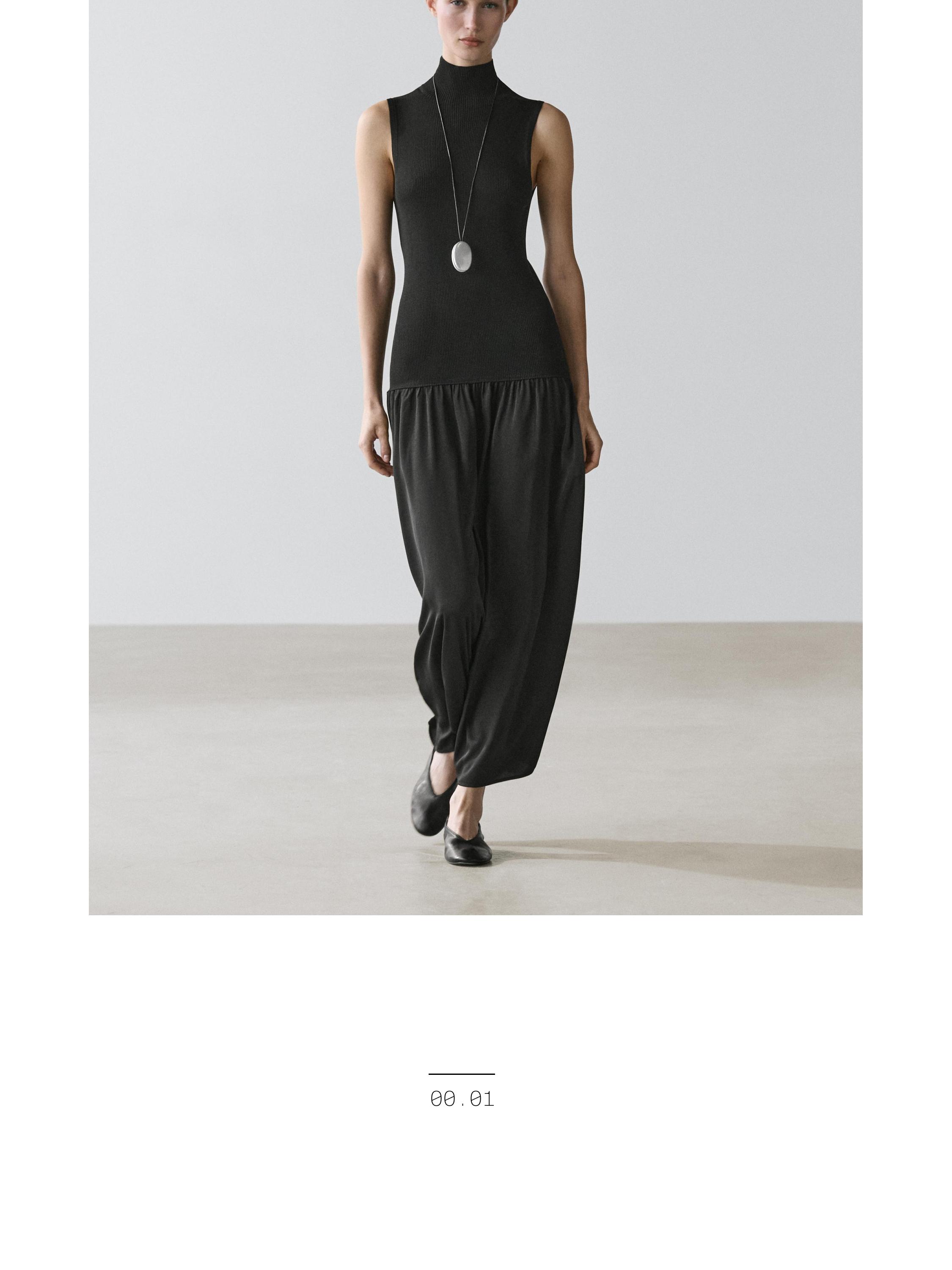 Conjunto de vestido negro sin mangas de cuello alto y falda amplia midi.