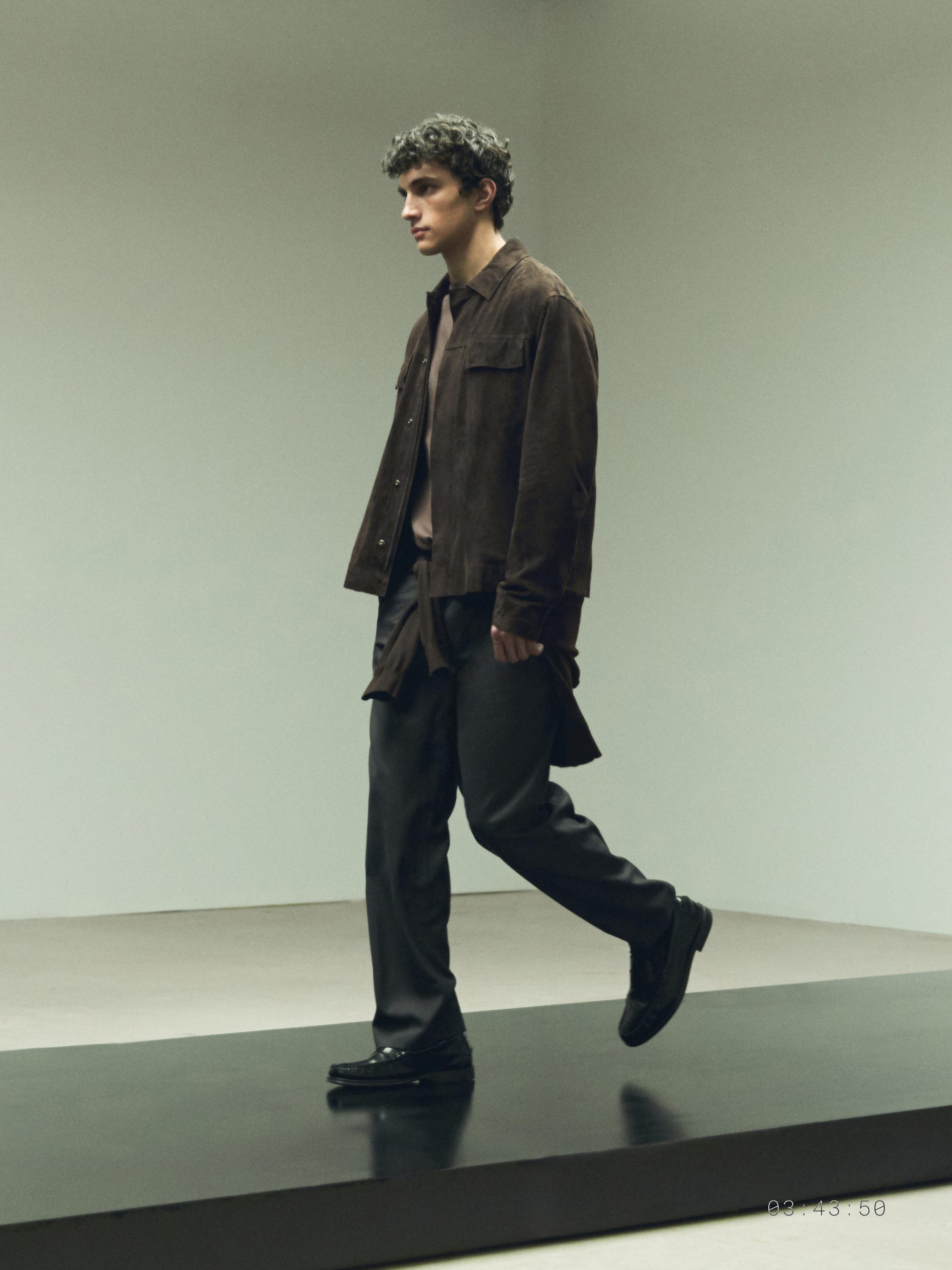 Komplet xhakete kafe me xhepa përpara dhe pantallona të errëta.