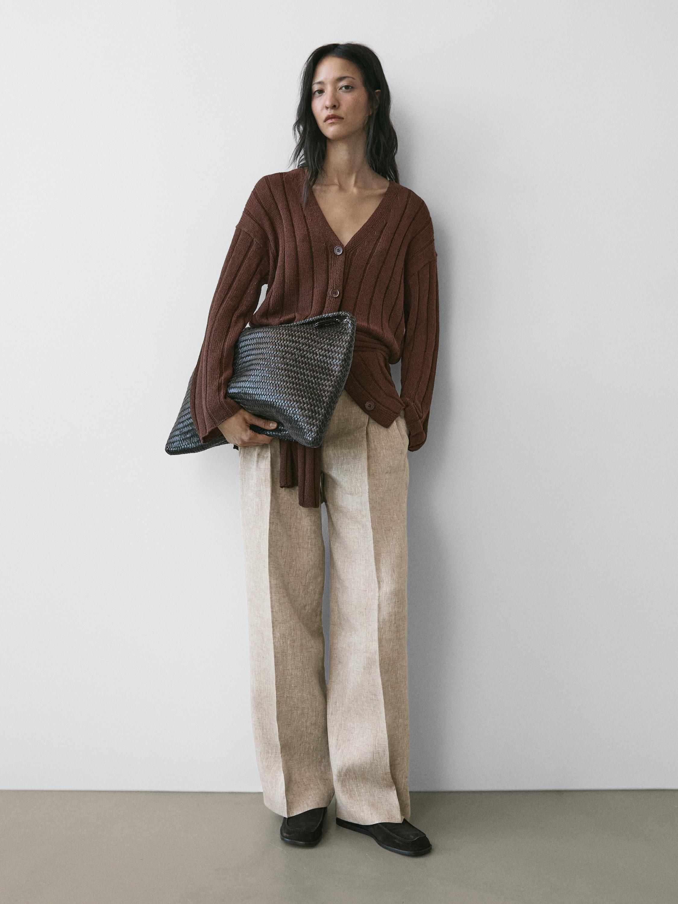 Bruine knoopvestset met beige broek met wijde pijpen.