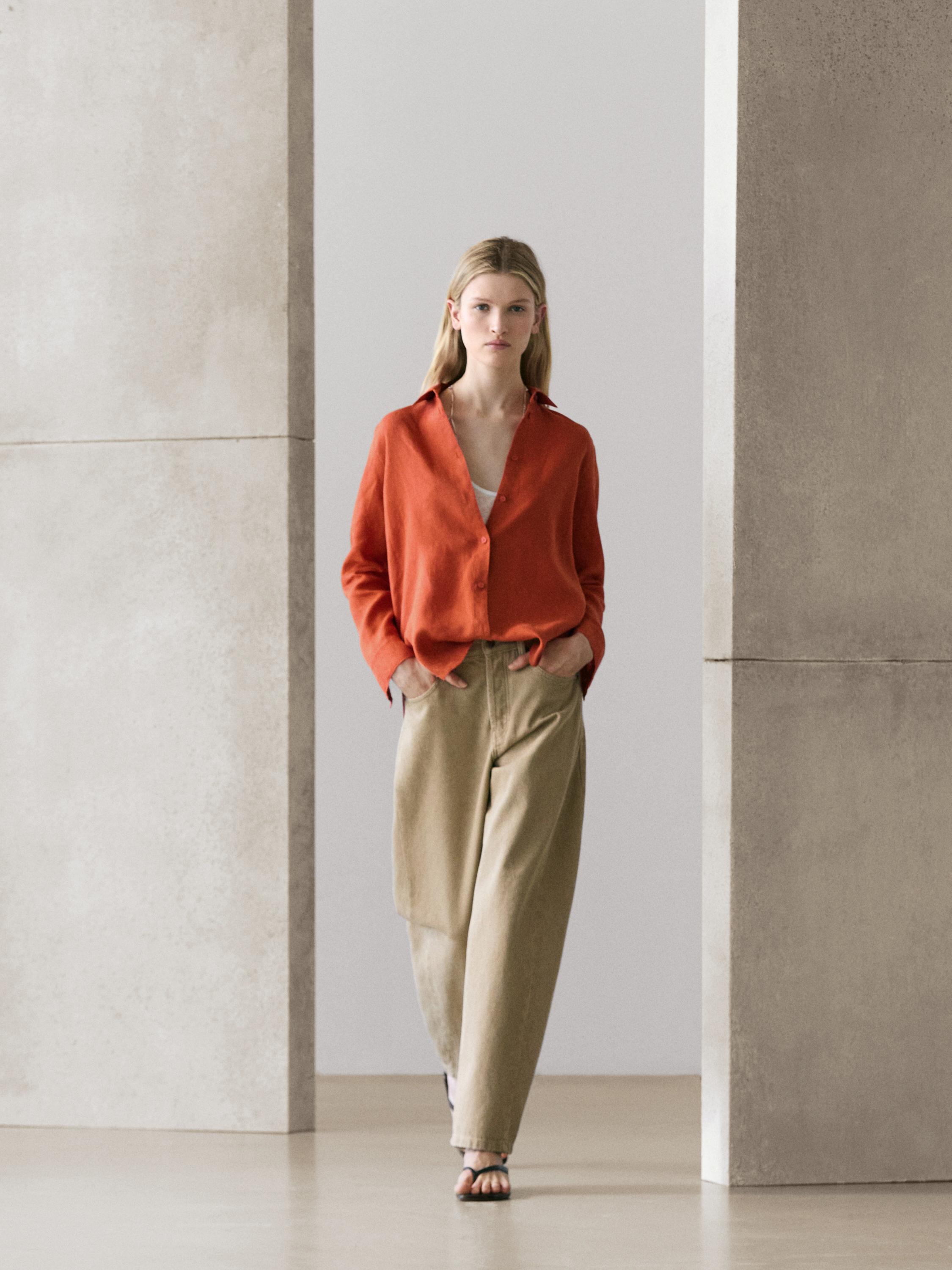 Ensemble fluide chemise boutonnée orange et pantalon large beige avec poches latérales.