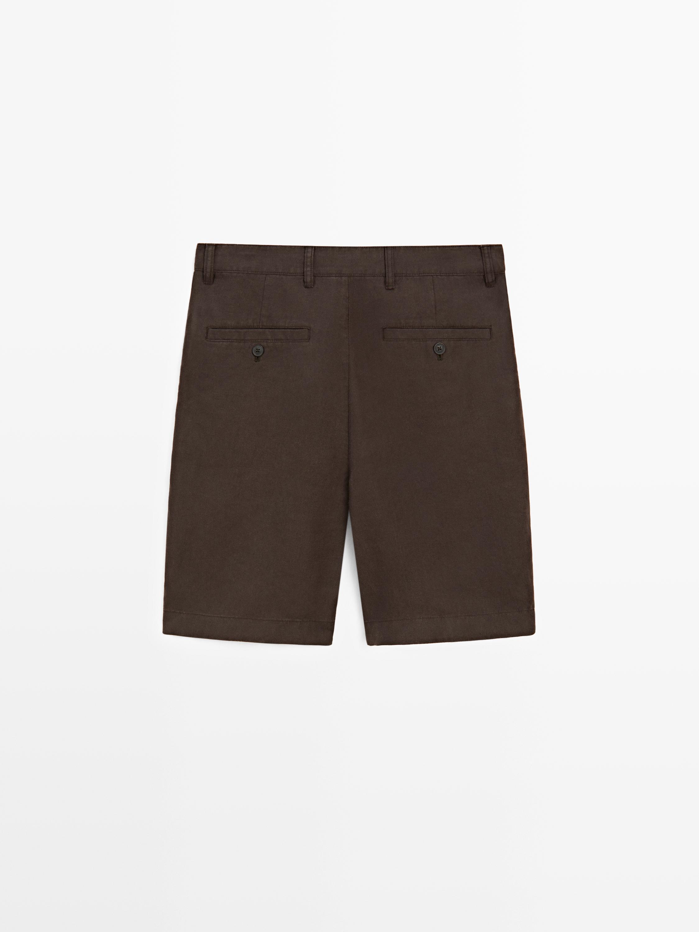 Vista posterior de bermudas marrones con bolsillos traseros con botón y trabillas para cinturón.