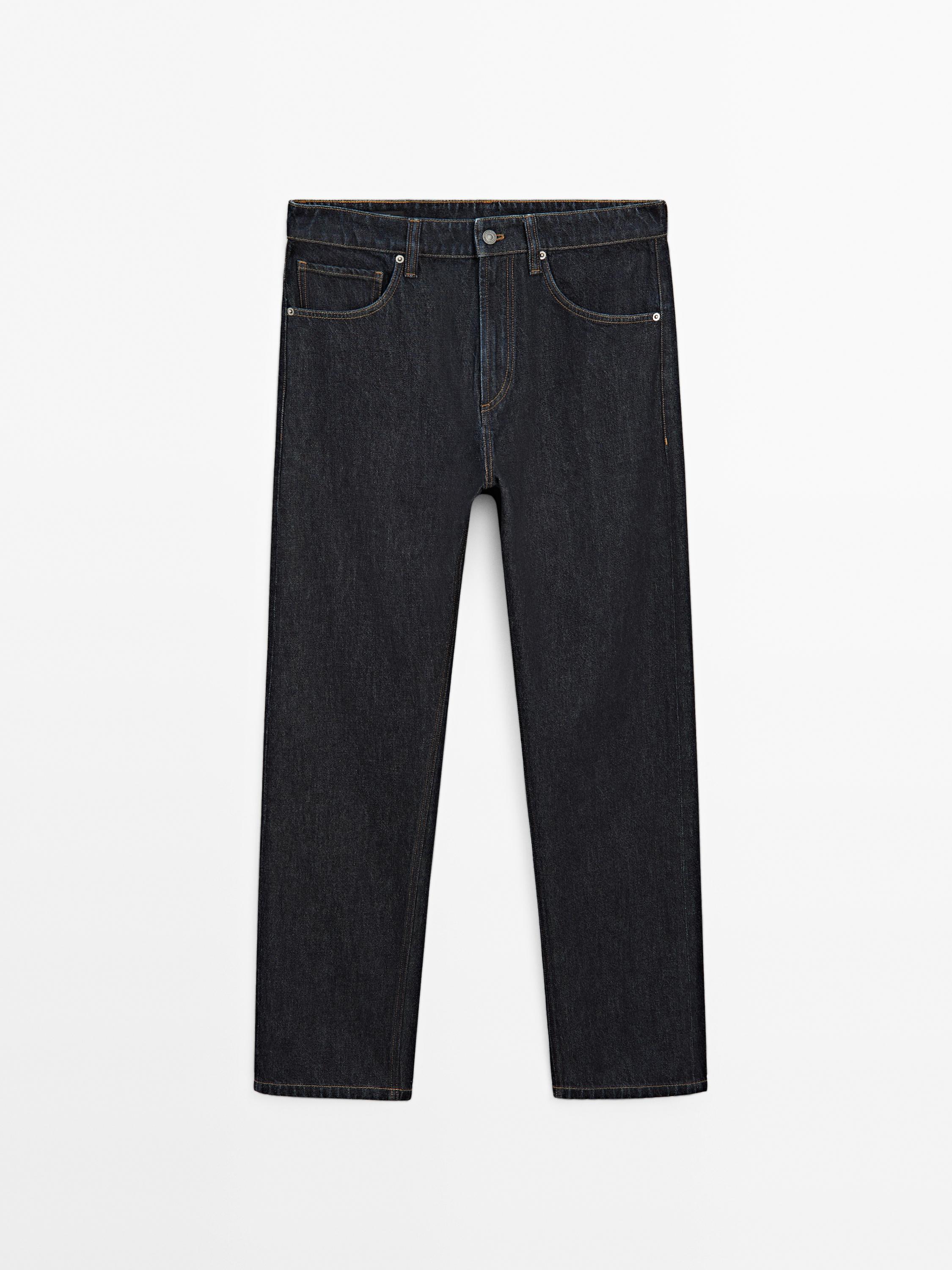 Предњи поглед индиго фармерки опуштеног кроја са предњим и задњим џеповима, закопчавањем на дугме и рајсфершлус.