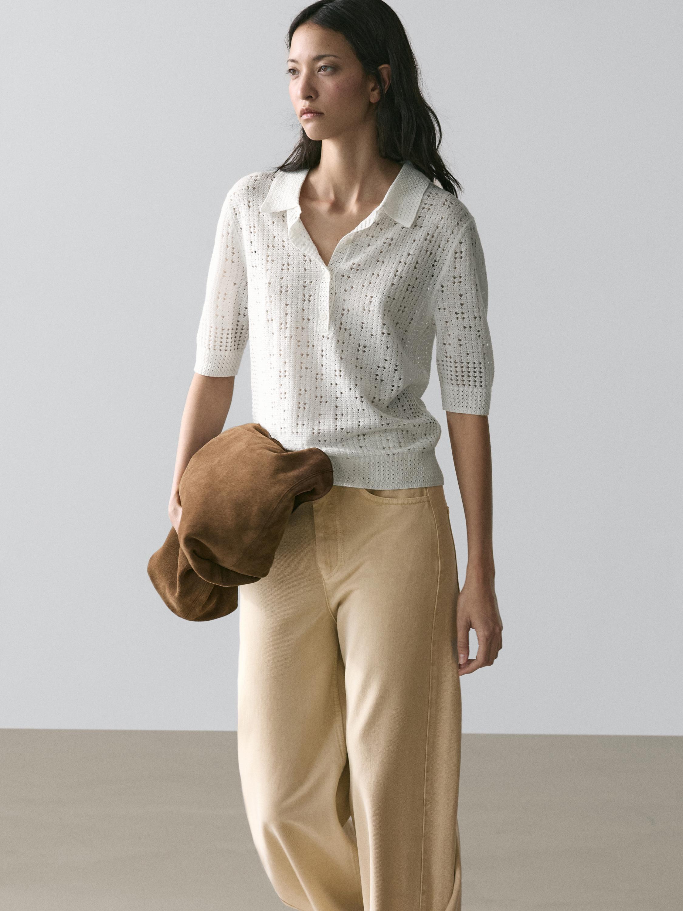 Súprava krémového pleteného svetra s polo golierom a béžových širokých nohavíc.