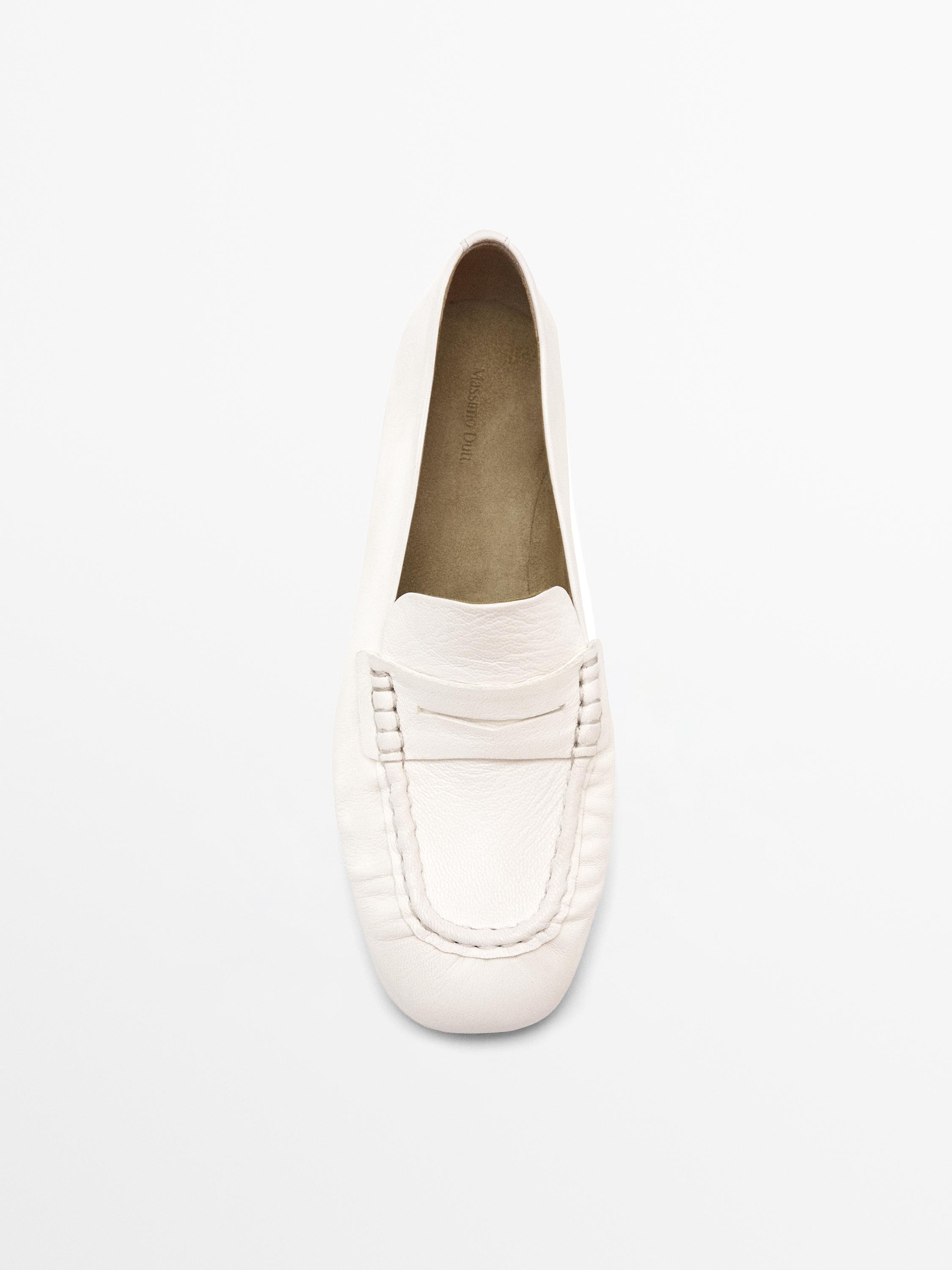 Front view of white loafer with visible stitching.
