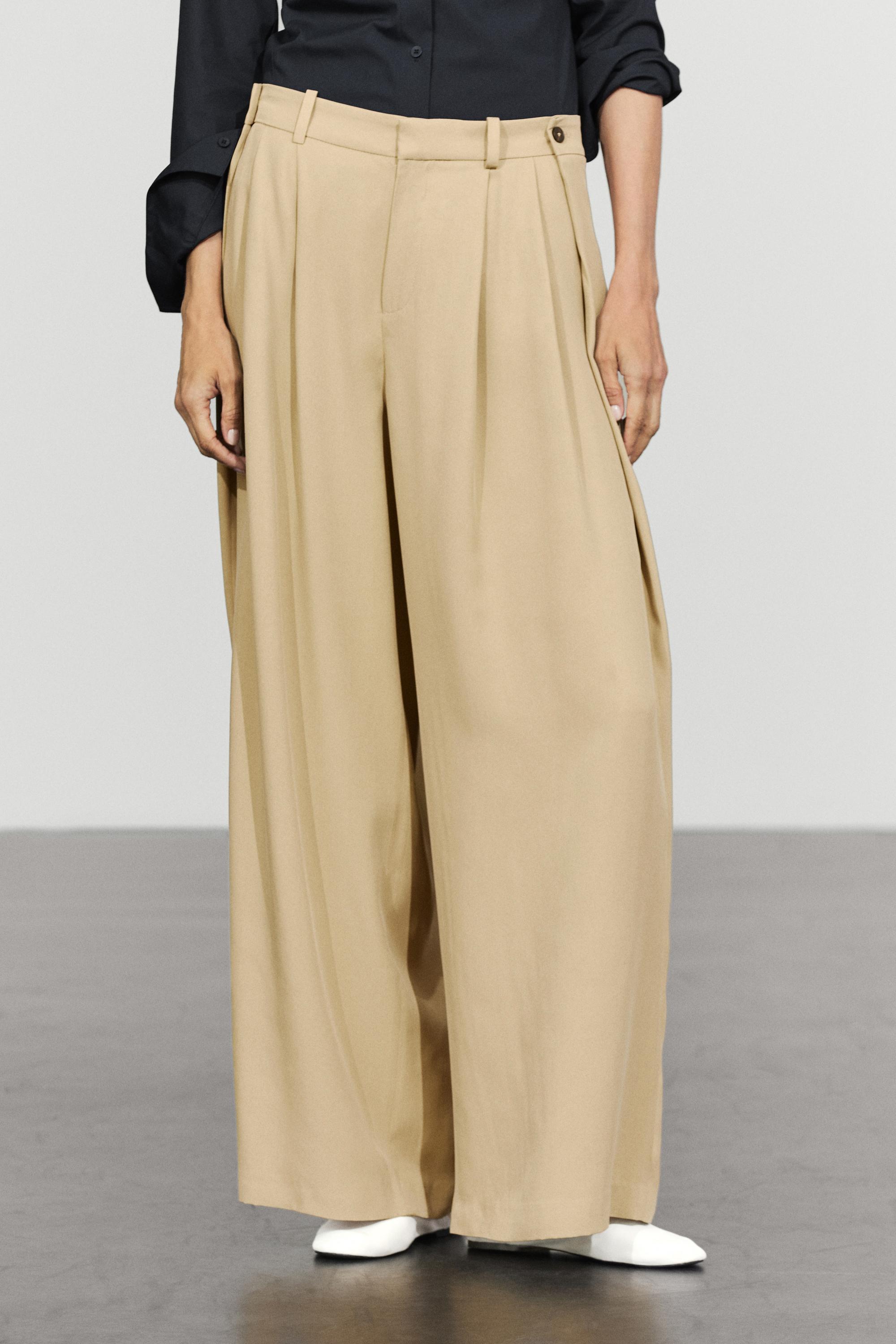 Flowing pleated pants with button detail