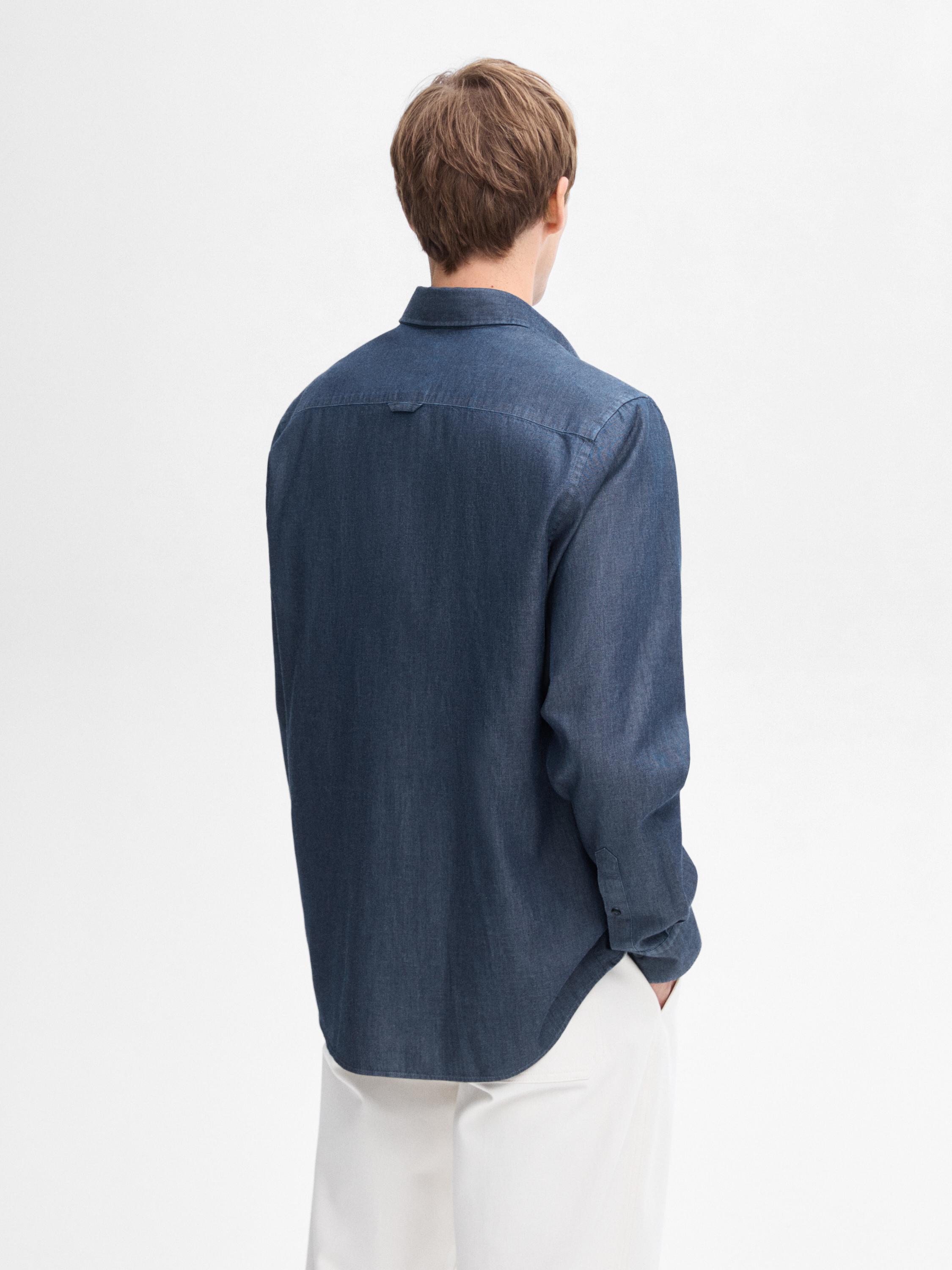 منظر خلفي لقميص أزرق بأكمام طويلة وياقة كلاسيكية.