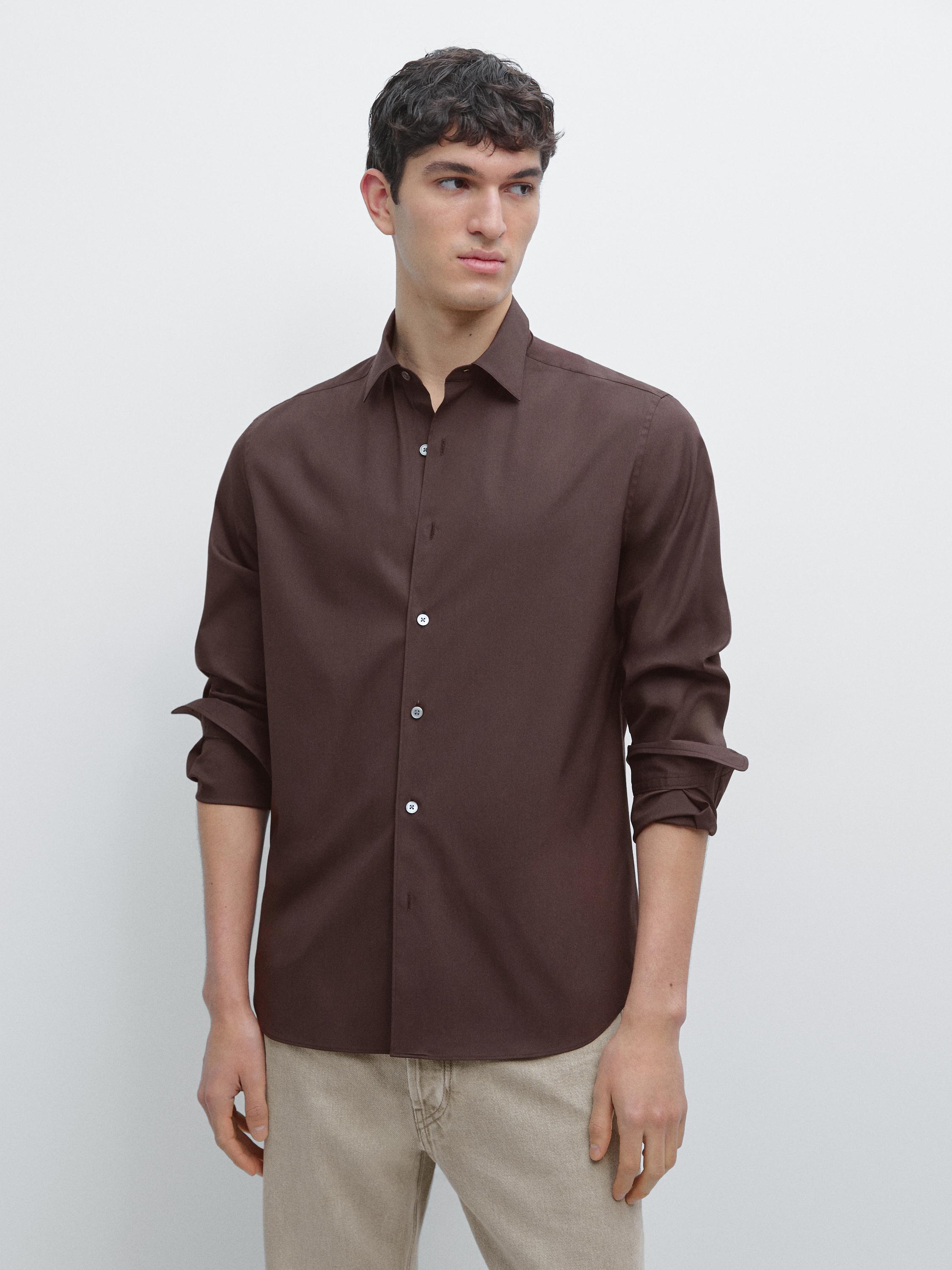 طقم قميص عنابي بأكمام طويلة مع أزرار بيضاء وبنطلون بيج.