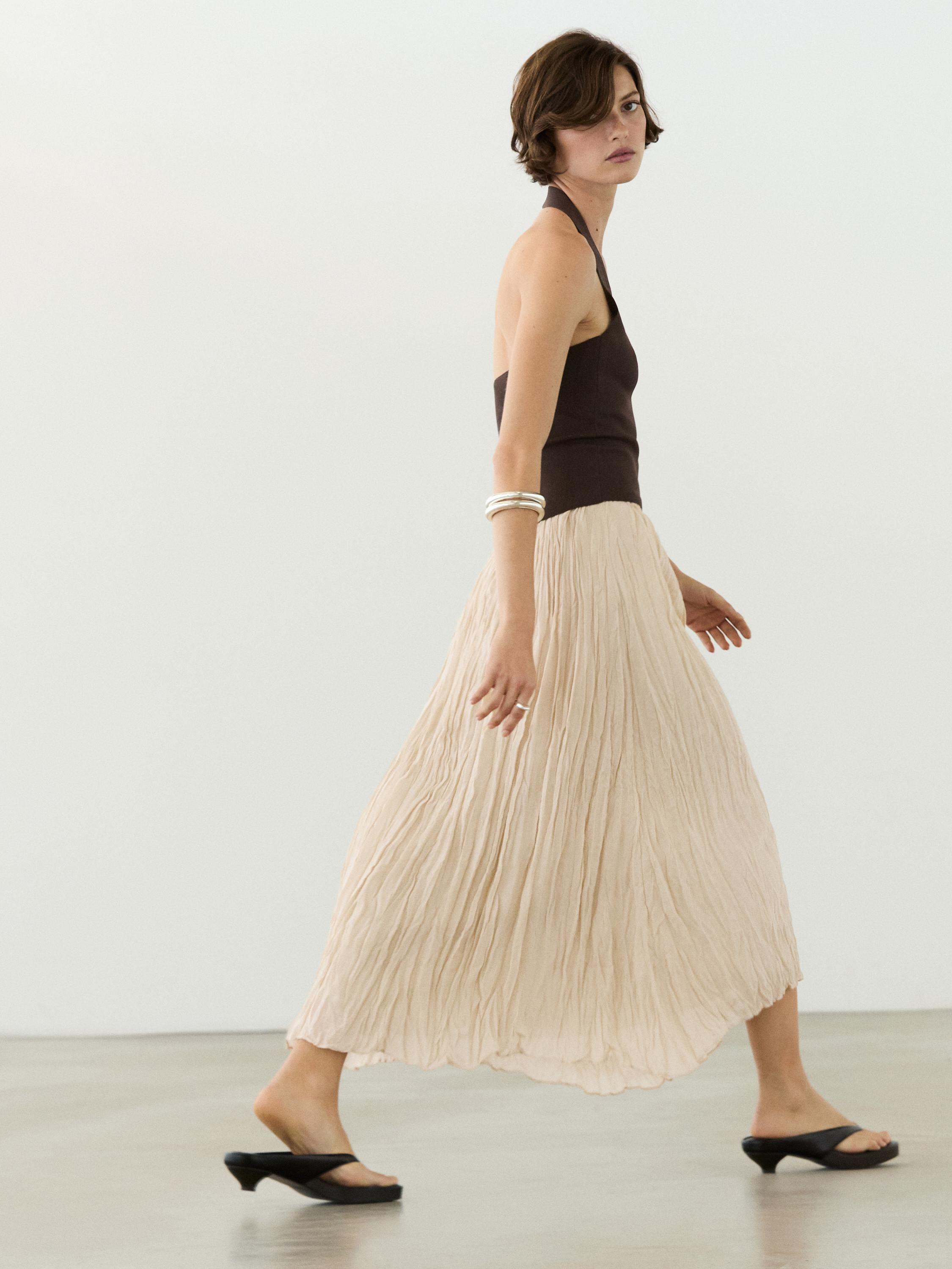 Raw pleated midi skirt and sleeveless brown top set.