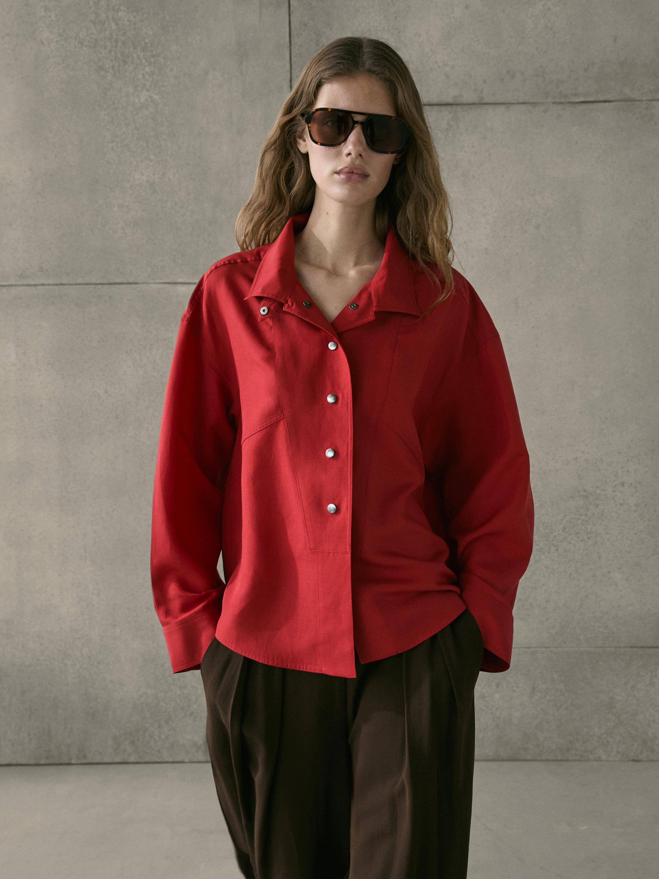 Flowy red shirt set with snap buttons and wide brown pants.