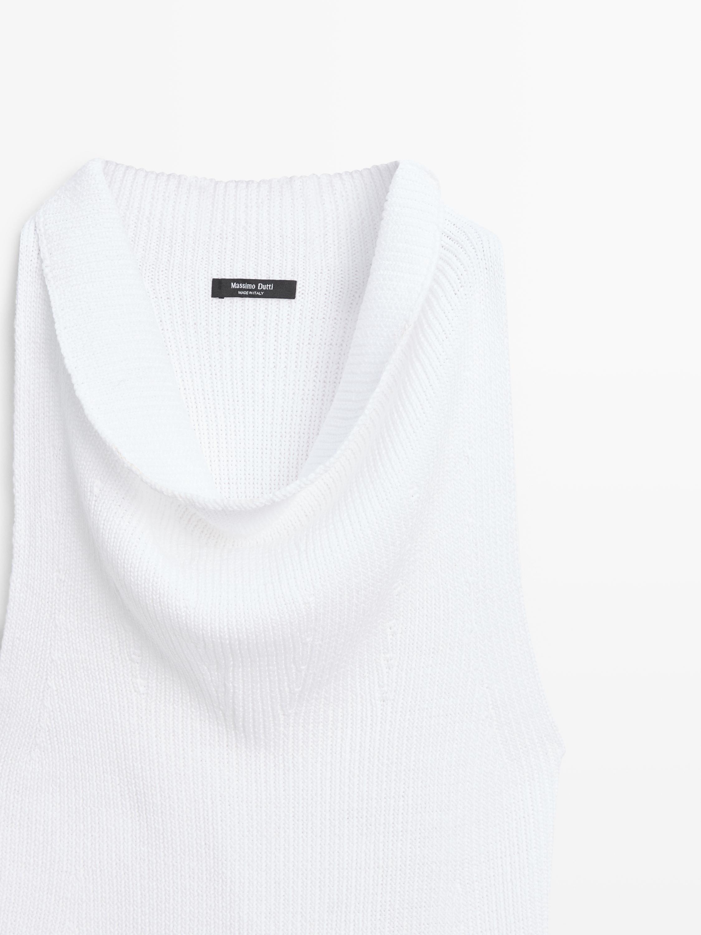 Primer pla de coll drapat de top blanc òptic, etiqueta visible amb text "Massimo Dutti Made in Italy".