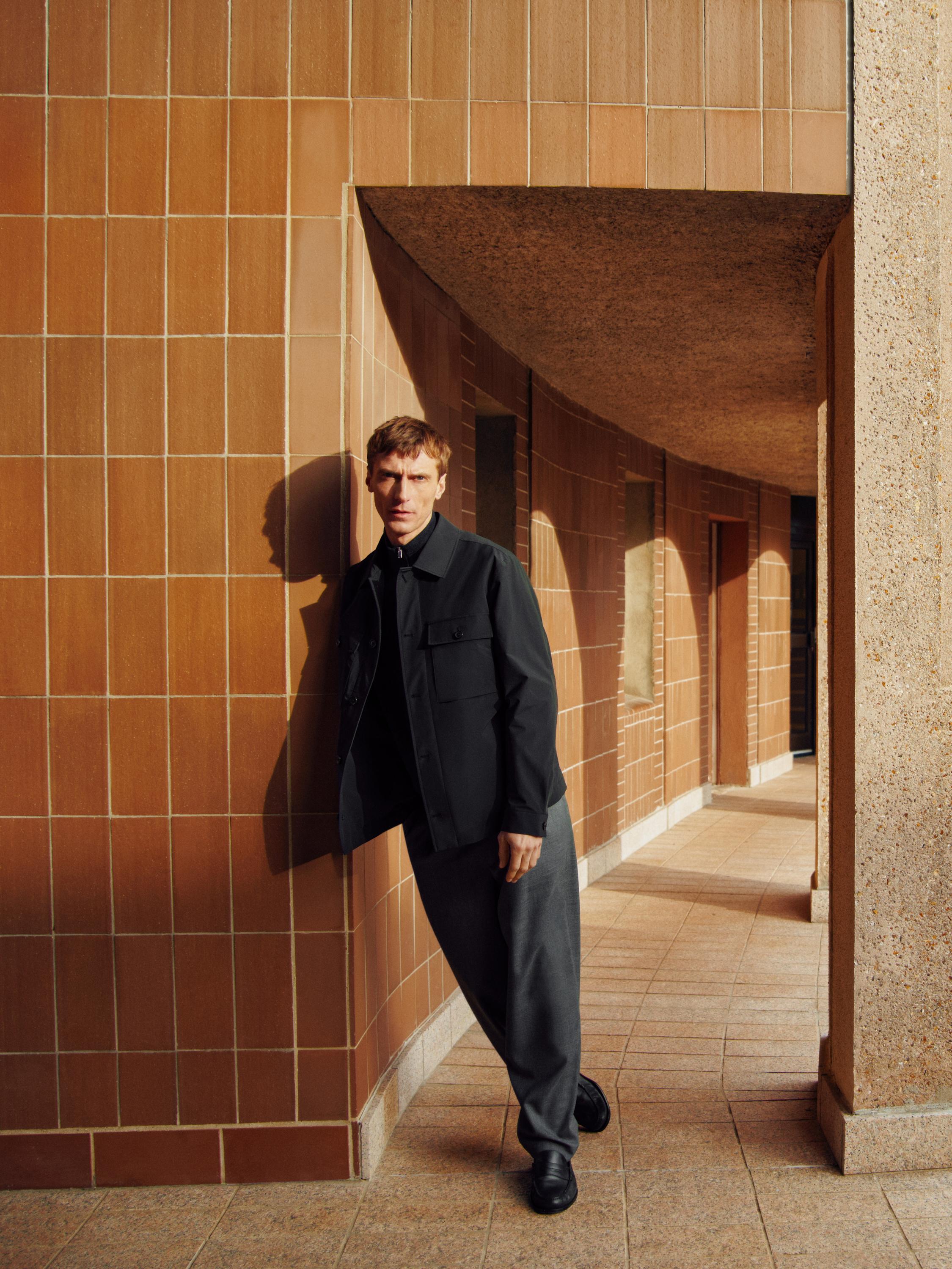 طقم جاكيت كحلي بجيوب أمامية وبنطلون رمادي فضفاض.