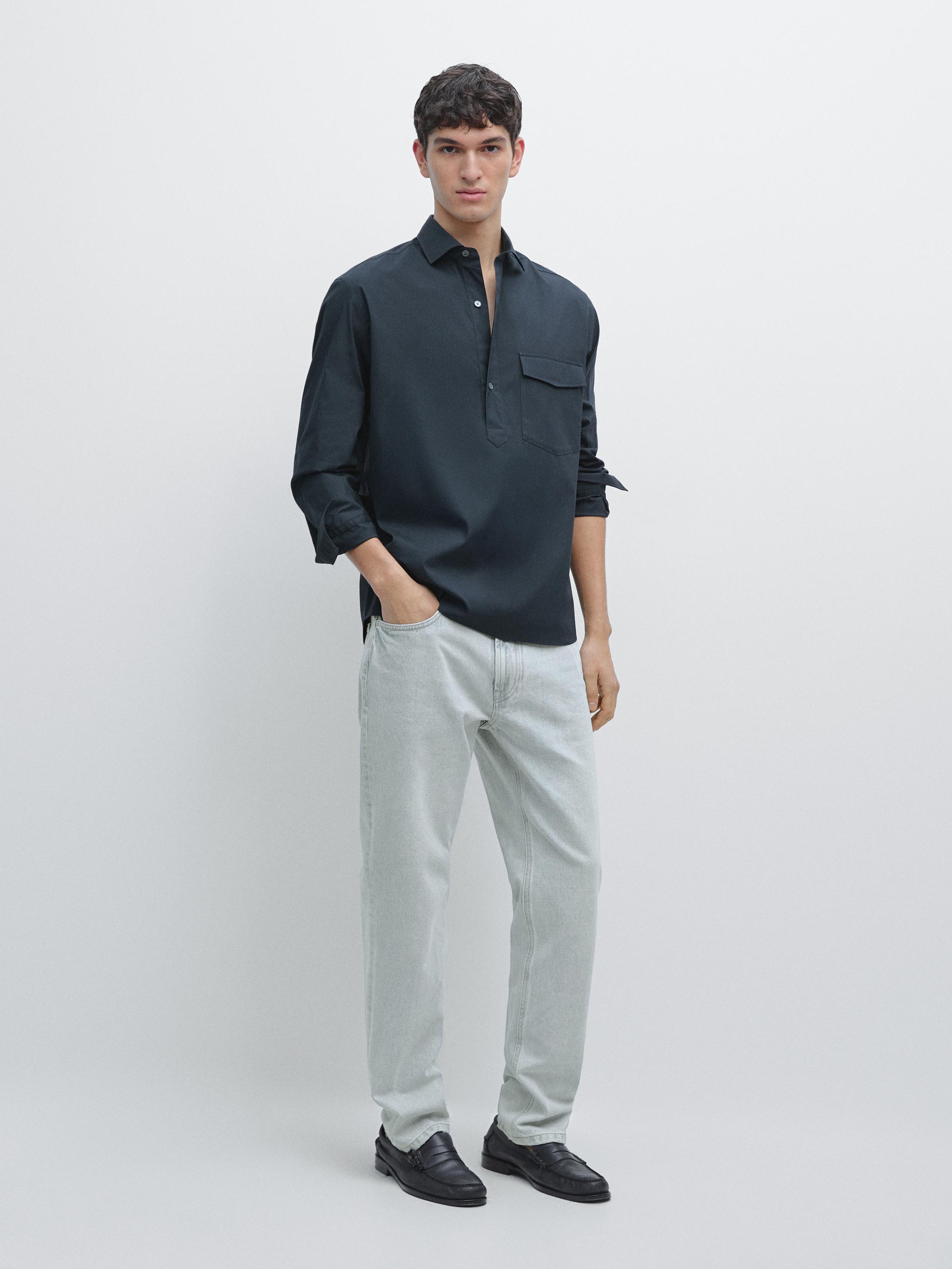 طقم قميص كحلي بجيب أمامي وبنطلون فاتح.